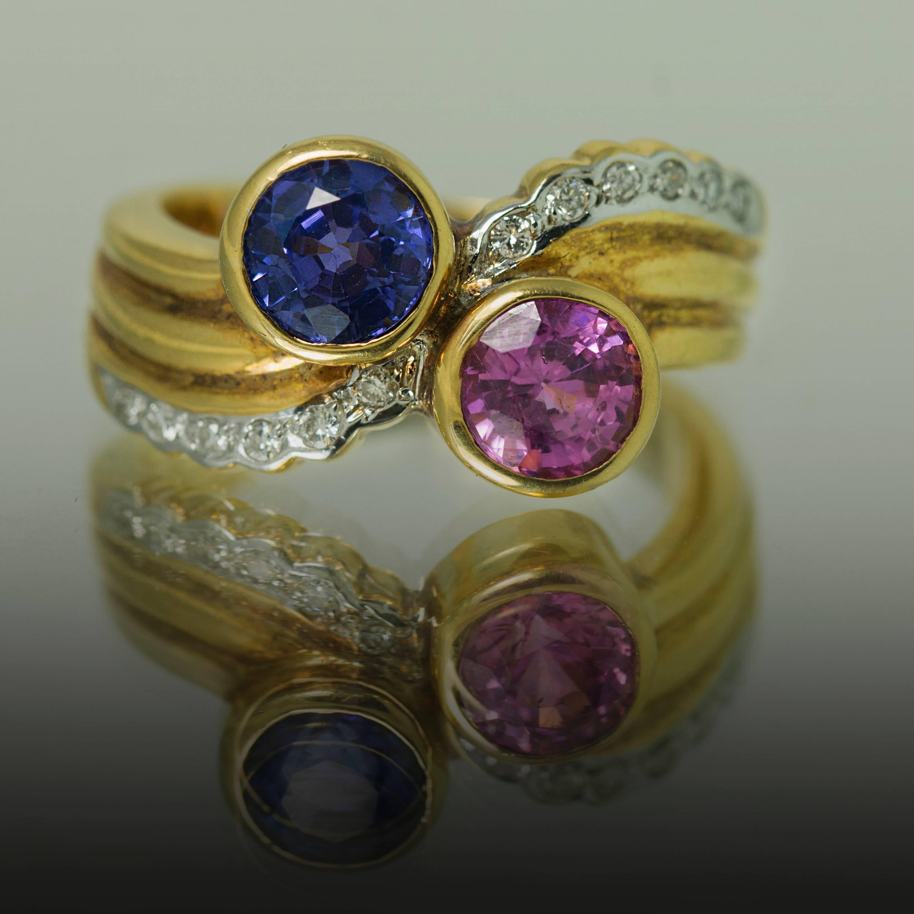 18k Sapphire Ring with 1 round blue sapphire weighing 1.25 carats, 1 round pink sapphire weighing 1.13 carat and 12 round diamonds = 0.25