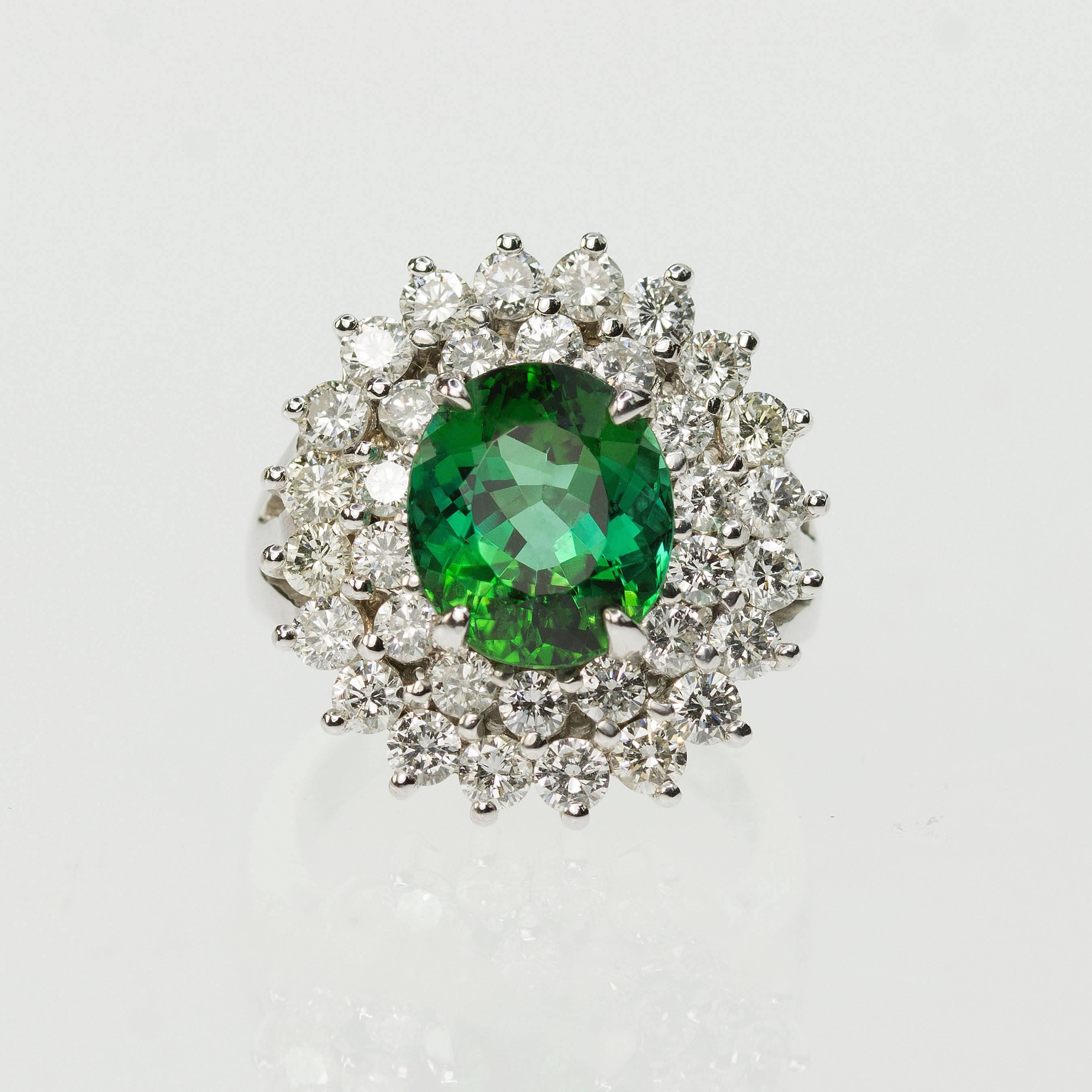 14k White gold ring with gorgeous oval green tourmaline weighing approximate  4.25 carats and 34 round brilliant diamonds weighing approximately 2.25 carats and being F-G in color and VS1-VS2 in clarity.