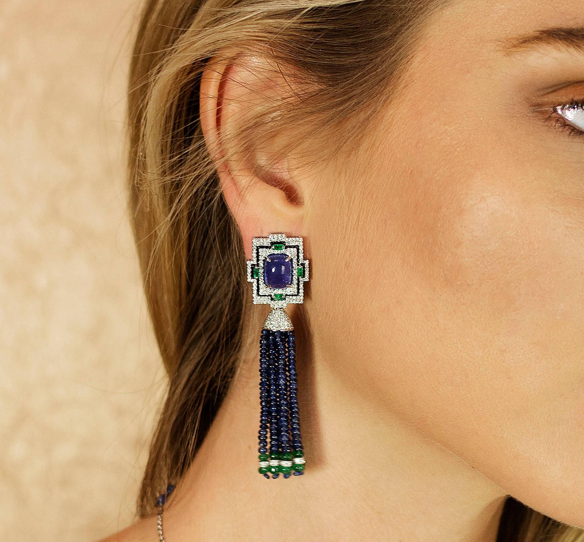 18K Tassle earrings with two Tanzanites weighing 8.89 carats, eight faceted Emeralds weighing 0.35 carats, faceted Sapphire beads weighing  62.63 carats, Emerald Beads weighing 10.78 carats and 28 black diamonds weighing 0.14 carats.