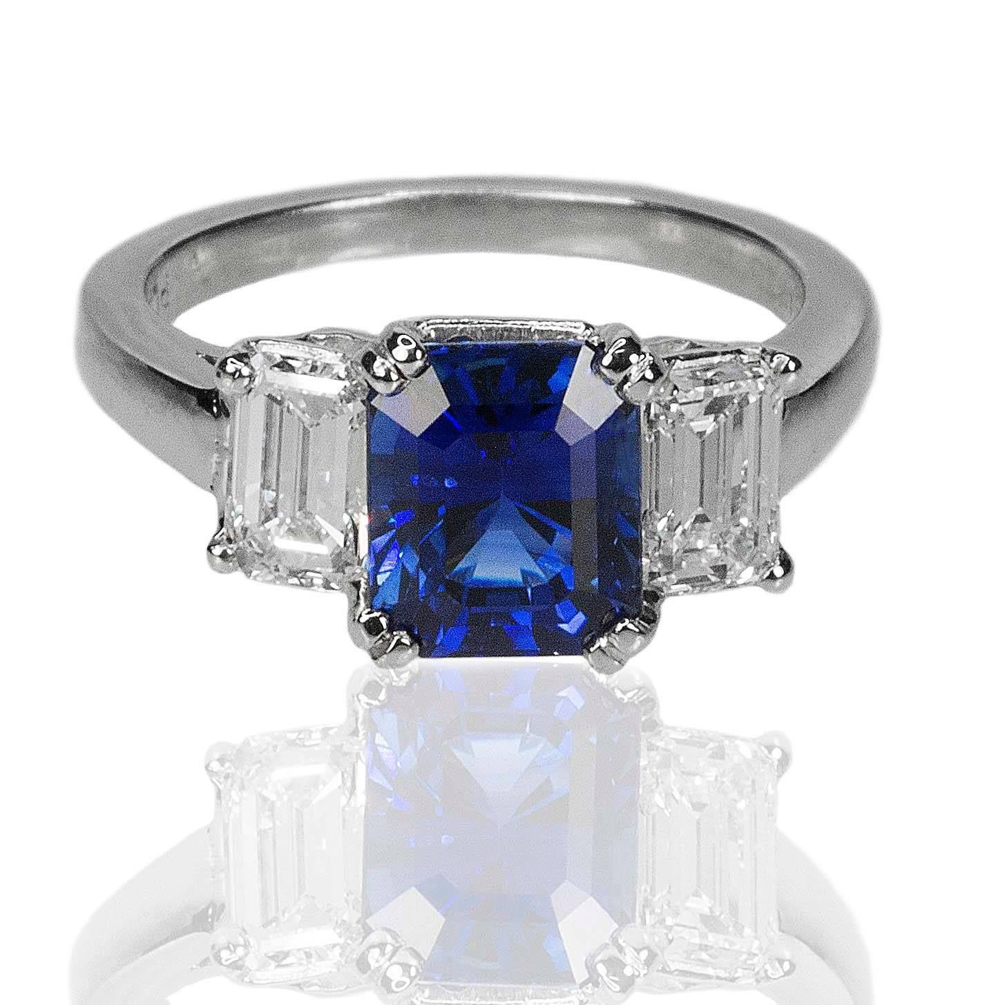 Platinum Ring with one AGL certified 2.98 carat emerald cut Royal Blue Sapphire and one0.57 carat  GIA certified E color VS2 clarity emerald cut diamond and GIA certified 0.56 carat D color VS1 clarity emerald cut diamond, 7.14g