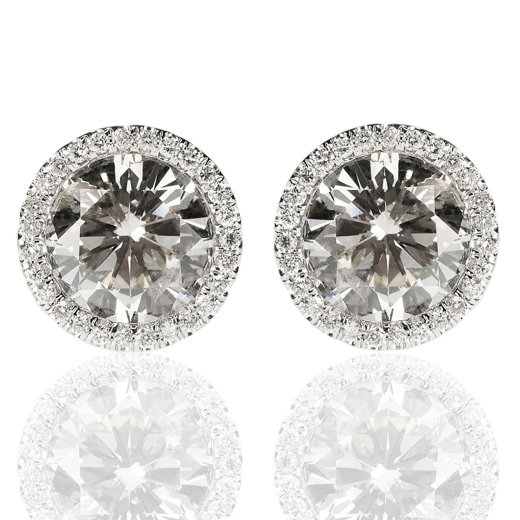 One pair of platinum earrings containing two modern round brilliant diamonds weighing approximately 3.70 carats total weight and 104 smaller round brilliant pave set diamonds weighing approximately 1.26 carats.  