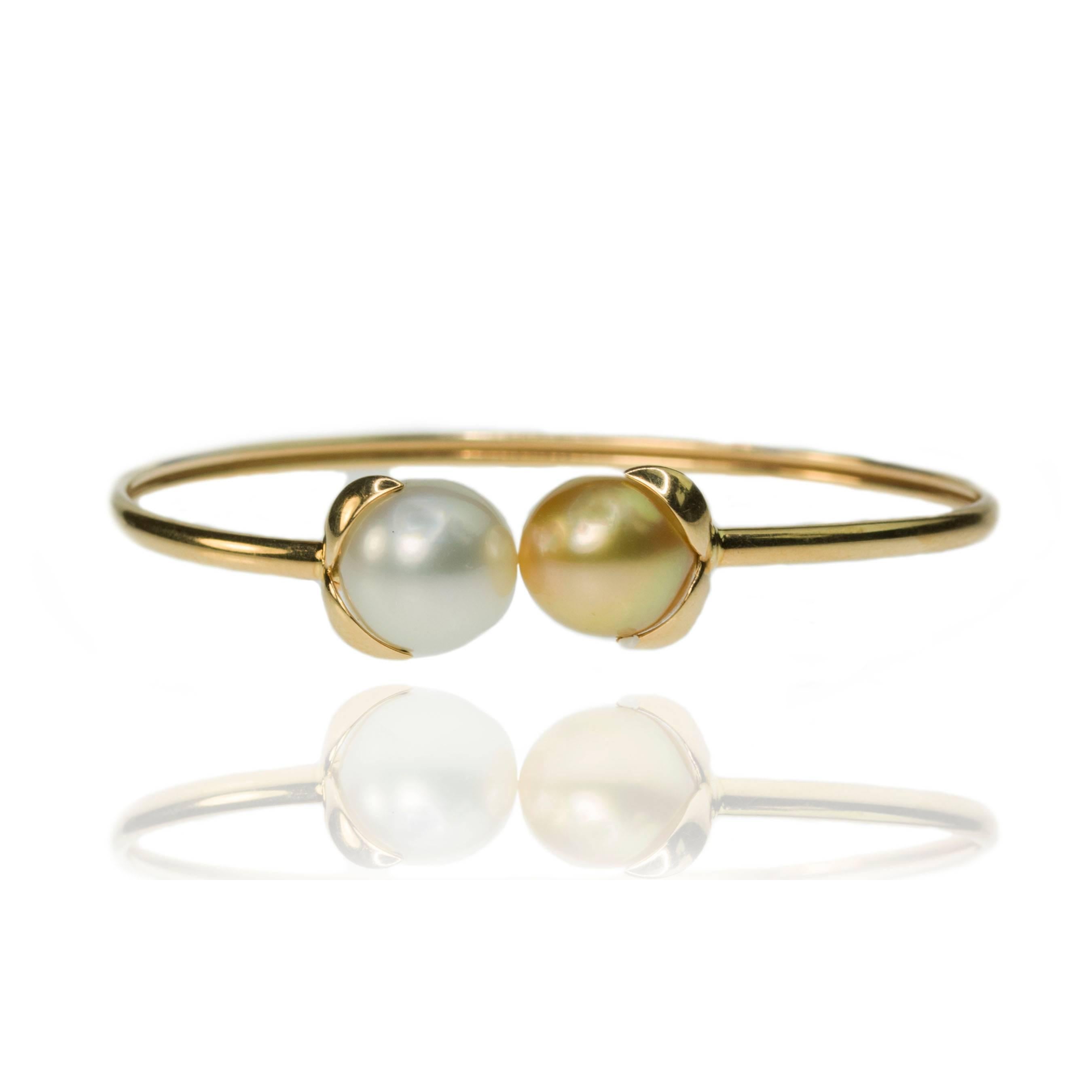 18k Yellow gold bangle by Iridesse. Flexible bangle with one 11.5mm white South Sea Pearl & one 11.5mm golden South Sea Pearl. 10.64g