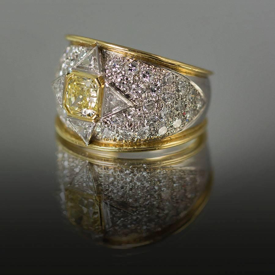 Hand Fabricated Ring by Keith Davis for Thayer Jewelers. Containing one GIA certified Fancy Yellow Radiant cut diamond weighing 1.01 carats and 4 trillion cut diamonds weighing 0.61 carats pave set round brilliant diamonds weighing 1.76 carats. Size