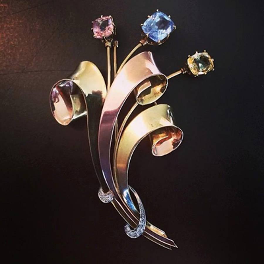 Magnifique broche rétro Tiffany & Co en or tricolore des années 1940 avec trois saphirs non chauffés rose, bleu et jaune pesant approximativement 10.00 carats et accentués par des diamants ronds pesant approximativement 0.20 carats.