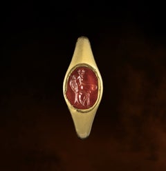 A Renaissance gold ring set with a carnelian intaglio. Old man seated on a rock