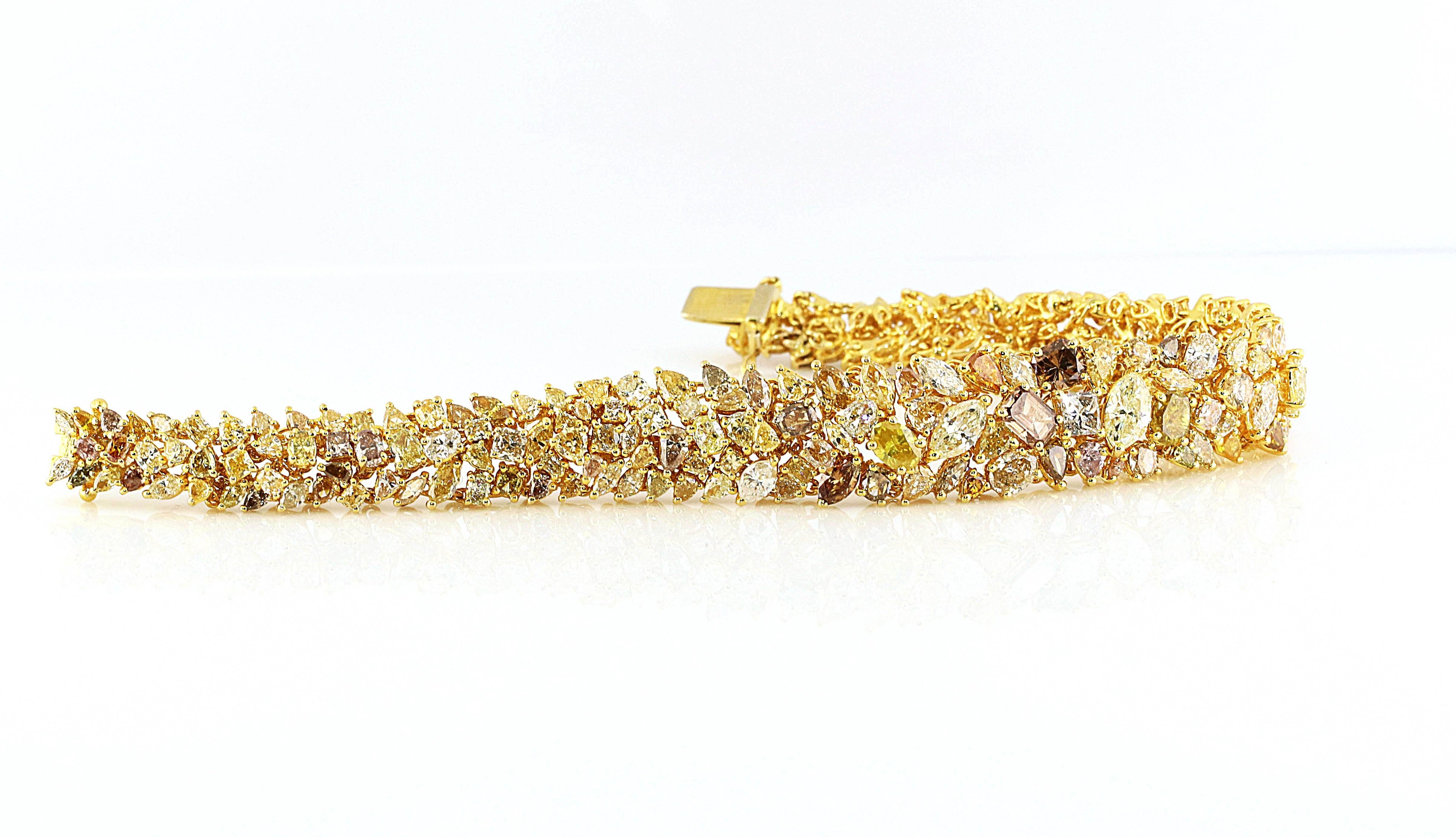 Yellows, pinks, browns and whites all set in gorgeous 18kt yellow gold make this an exquisite bracelet. Over 20.25 carats of natural multi-colored diamonds of all different shapes. There are many pear cuts, marquise cuts, round cuts and emerald