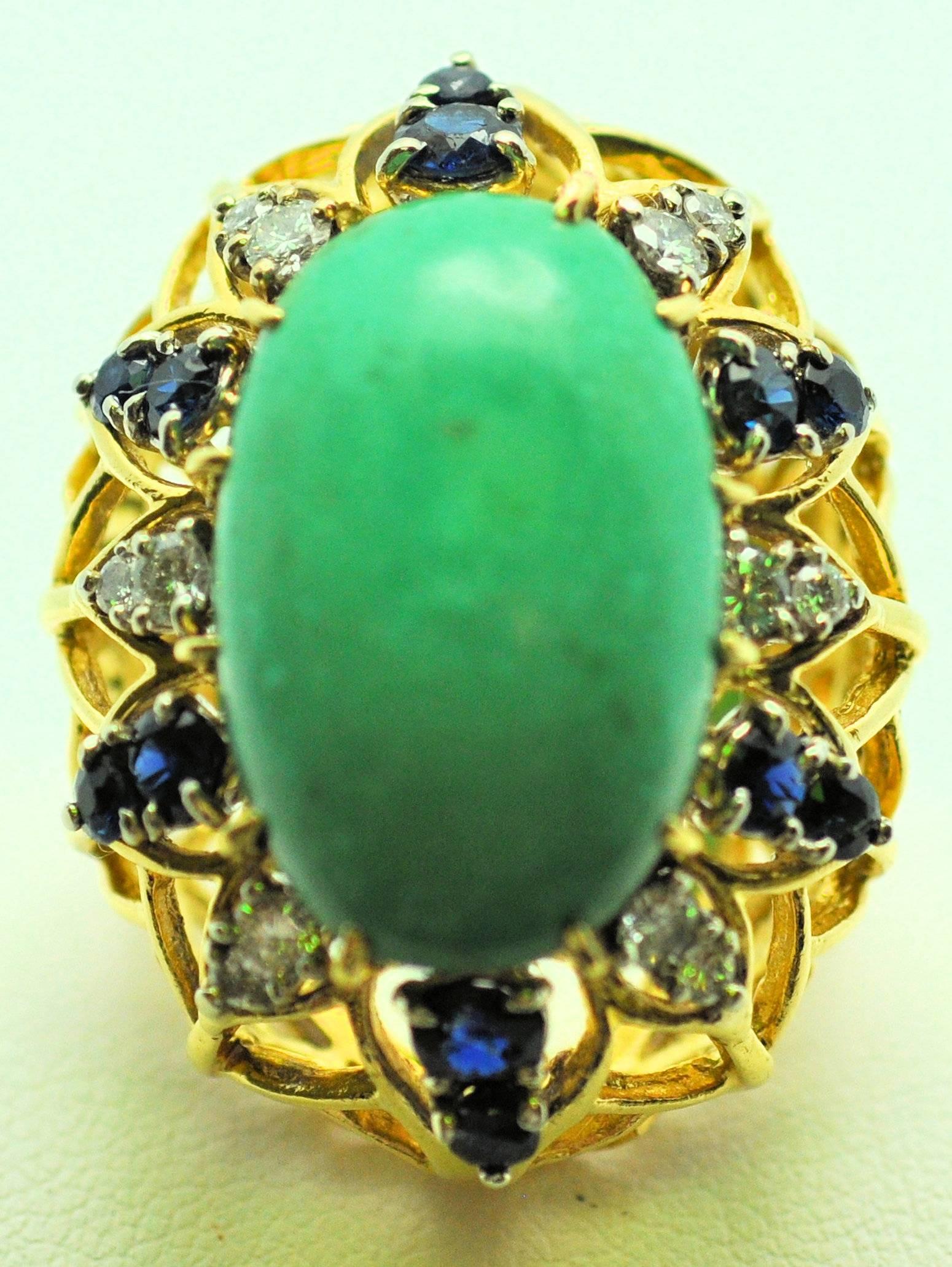 18 Karat yellow gold ring with turqoise set high surrounded by alternating sapphires and diamonds.  
Center large turquoise cabochon measuring 21.5 x 14 mm.
12 round sapphires 1.25 carat total weight 
12 round diamonds 0.45 carat total weight