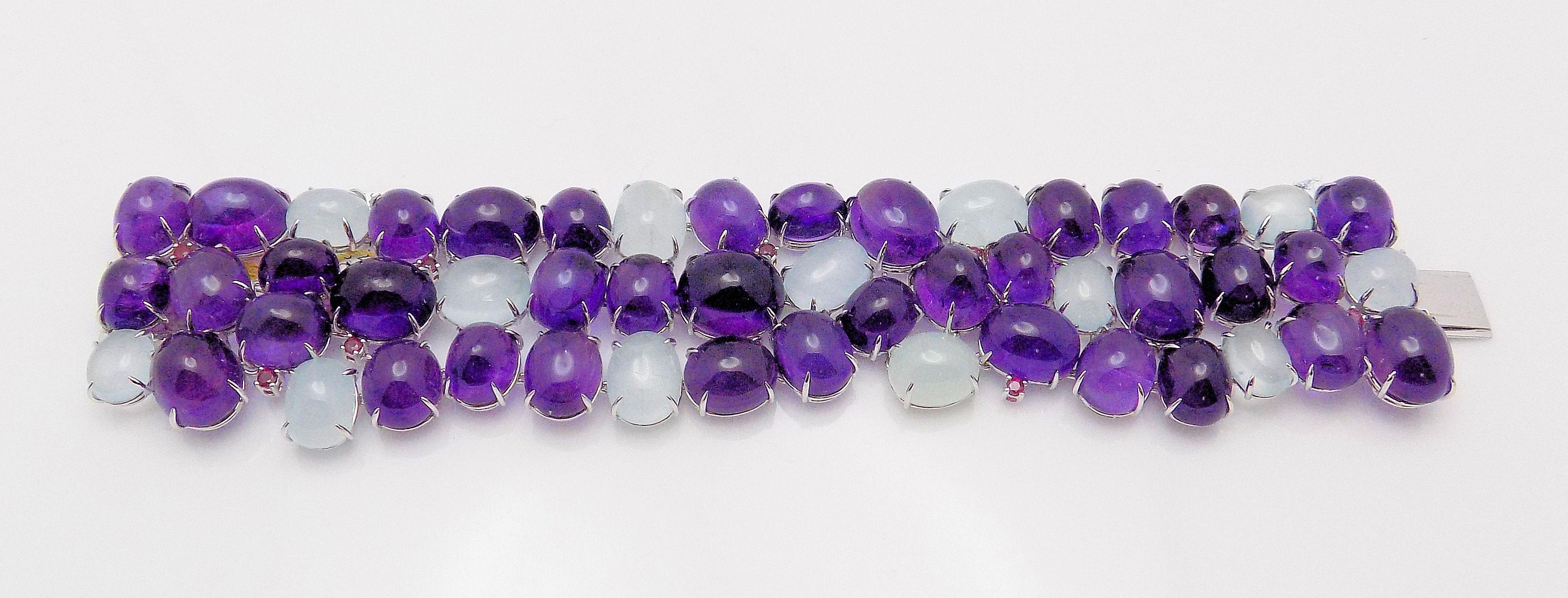 Stunning 18 Karat White Gold Bracelet featuring 37 Oval Cabochon Amethysts; 13 Oval Cabochon Aquamarines 309.43 Carat Total Weight; 8 Round Rubies 0.32 Carat Total Weight; Signed: Z. 66.7 DWT or 103.73 Grams.