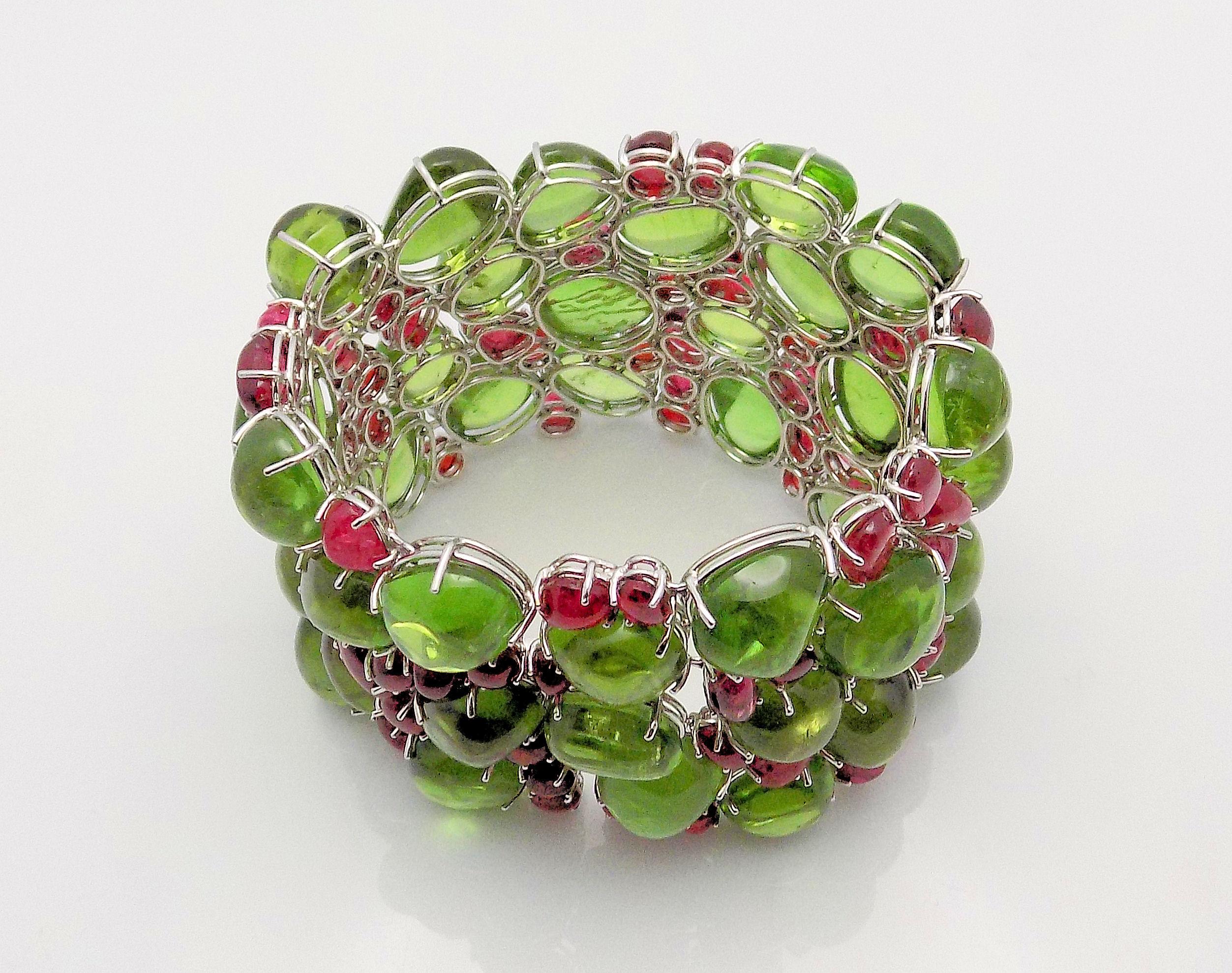 Gorgeous 18 Karat White Gold Handmade Bracelet Set with Cabochon Cut Peridots 585.62 Carat Total Weight and Cabochon Cut Red Spinels 92.97 Carat Total Weight; 7.75” Long 2.25” Wide; 143.1 DWT or 222.55 Grams.