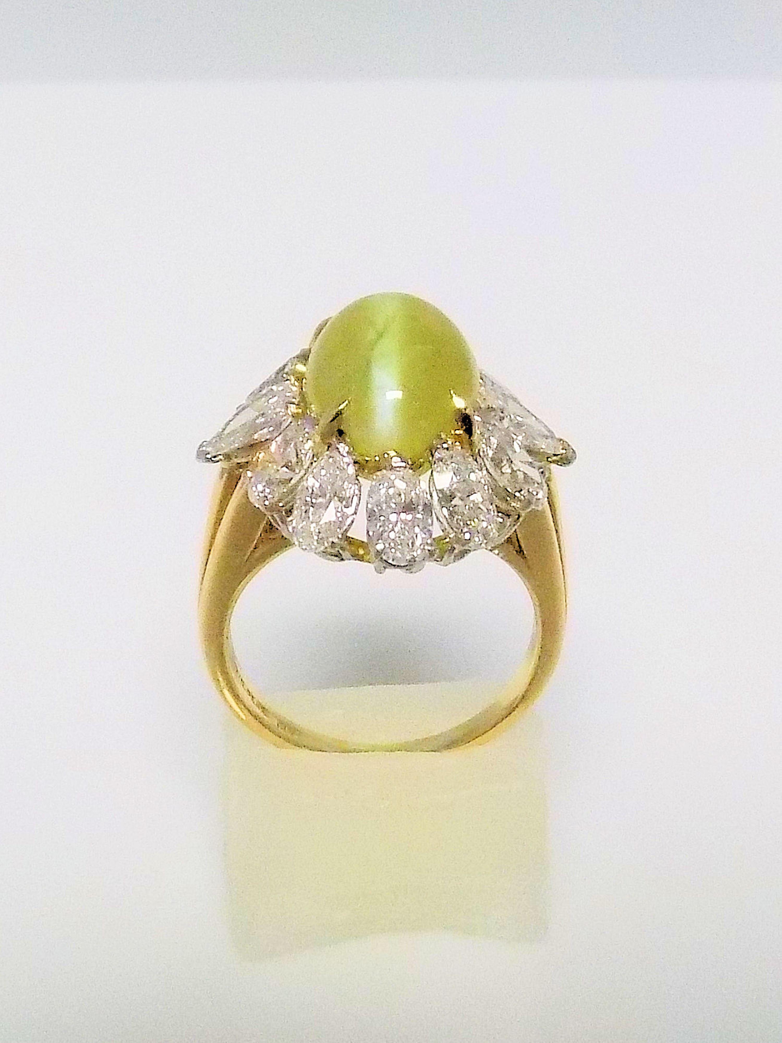 Phenomenal 18 Karat Yellow Gold Ring Featuring 1 Oval Cabochon Cut Cat's Eye Chrysoberyl (with milk & honey phenomena), Very Fine 11.71 Carat; surrounded by 10 Oval and 2 Pear Shaped Diamonds 4.50 Carat Total Weight, VVS-VS, F-G.  Finger Size 7.75;
