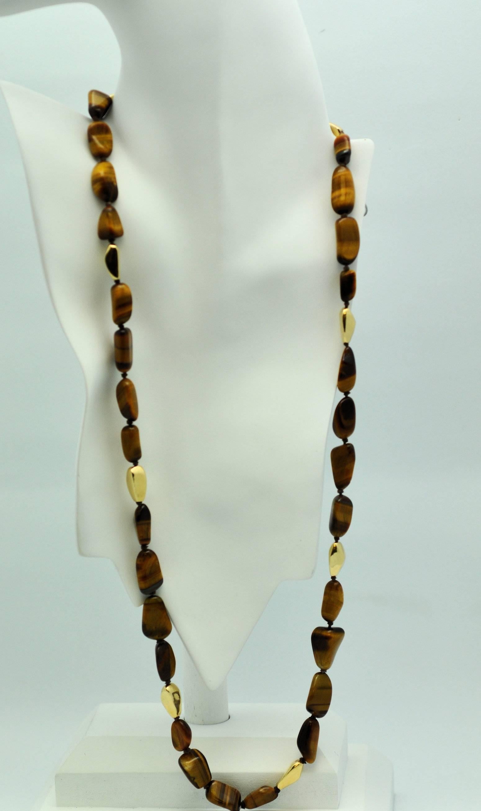 Long strand fine quality tigers eye baroque shape beads with matching shape gold bead necklace.  From VCA.  Rich golden-brown color. Strung continuously, no clasp.  30 inches long.  Perfect for fall. 