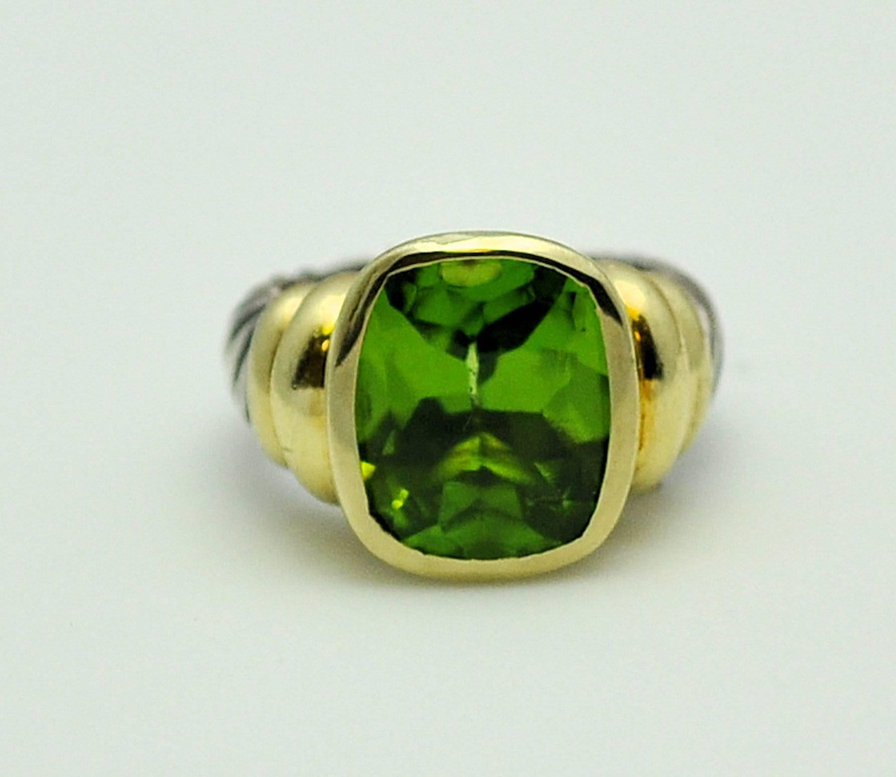14K yellow gold and sterling silver David Yurman Noblesse Peridot ring. The peridot is bezel set and measures 15 x 12 mm.  Buff-top, faceted pavilion. This model is retired and highly sought after, a wonderful large peridot weighing approximately