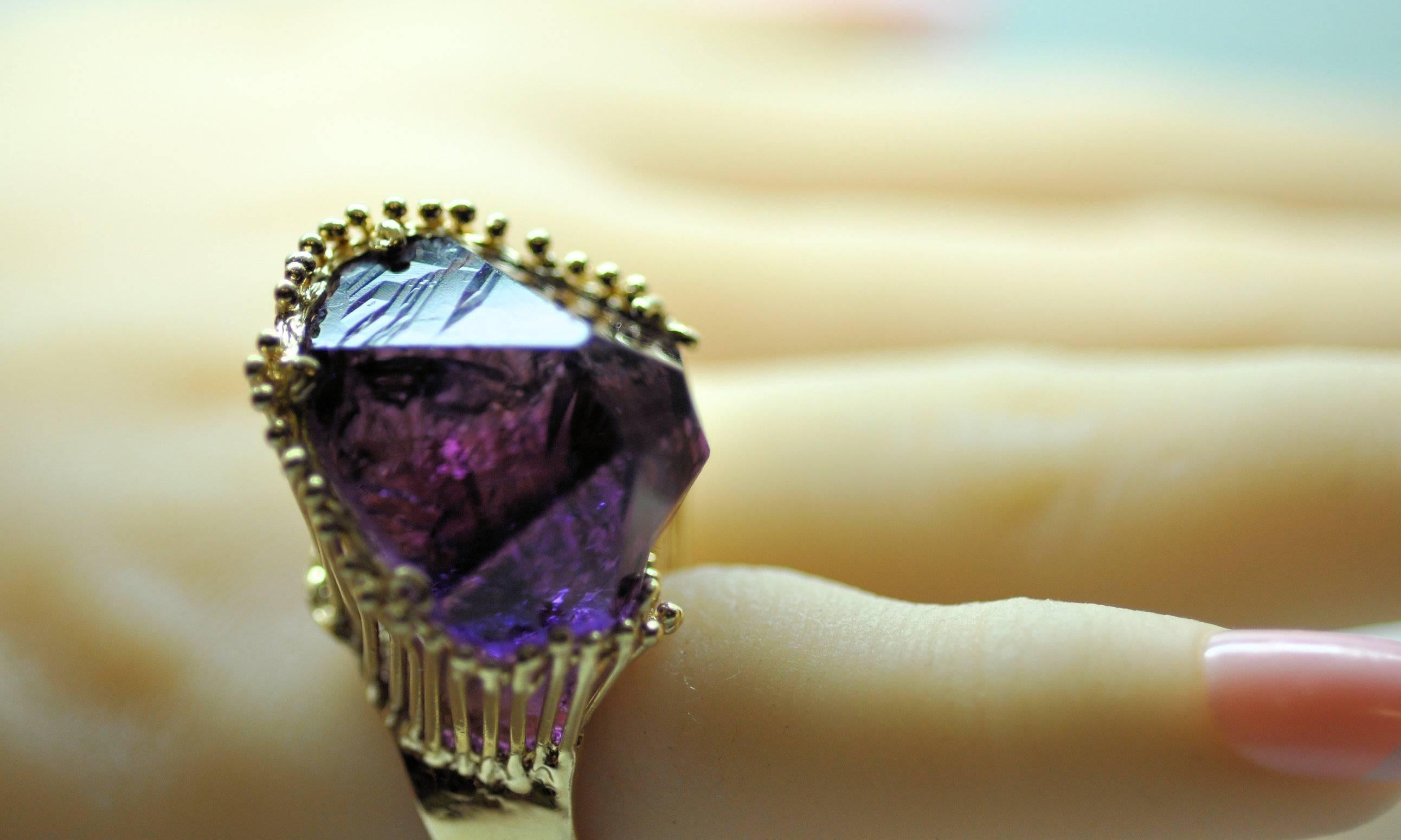 This fabulous and funky ring is artisan designed and holds a large natural amethyst crystal point weighing approximately 30.00 ct. in beaded wire setting.  14K yellow gold and size 4.5.  Can be sized.