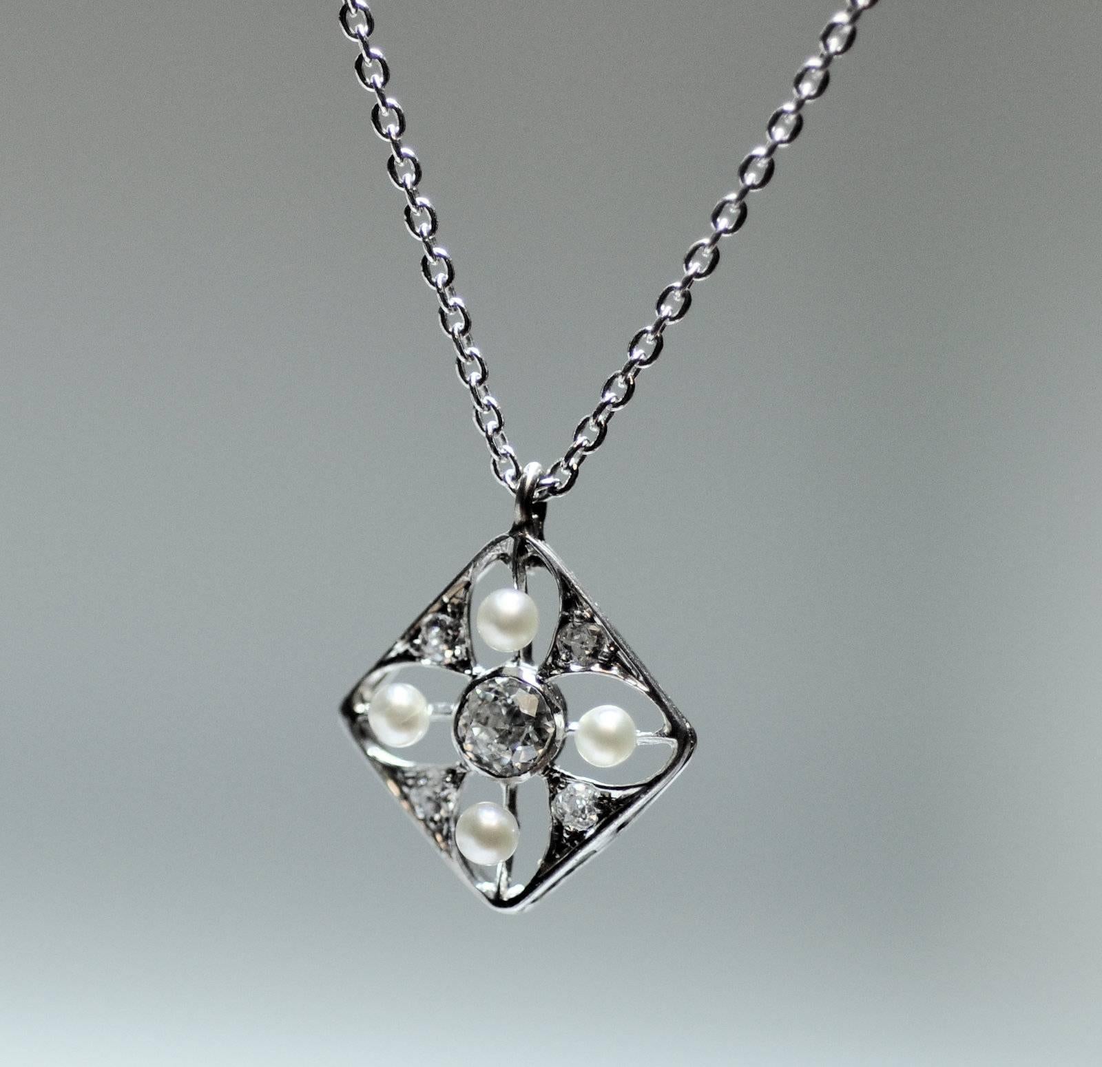 A sweet pendant made of platinum and set with five Old Mine cut diamonds 
 .22 Carat total weight of grade SI, G.  There are four seed pearls measuring 2 mm. each.  14K white gold cable chain 18 inches.  1.9 dwt.  Chain is new. 