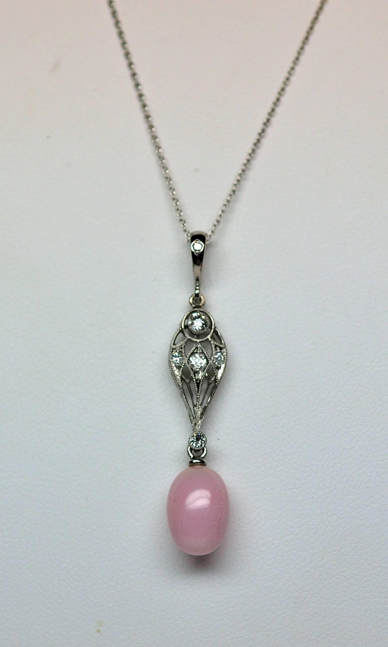 A fine quality natural conch pearl occurs only once in 100,000 conch pearls.  This pearl has the most desired pink color and perfect oval shape. Note the flame characteristic.  Antique platinum pendant with diamonds.  Modern platinum bail set with