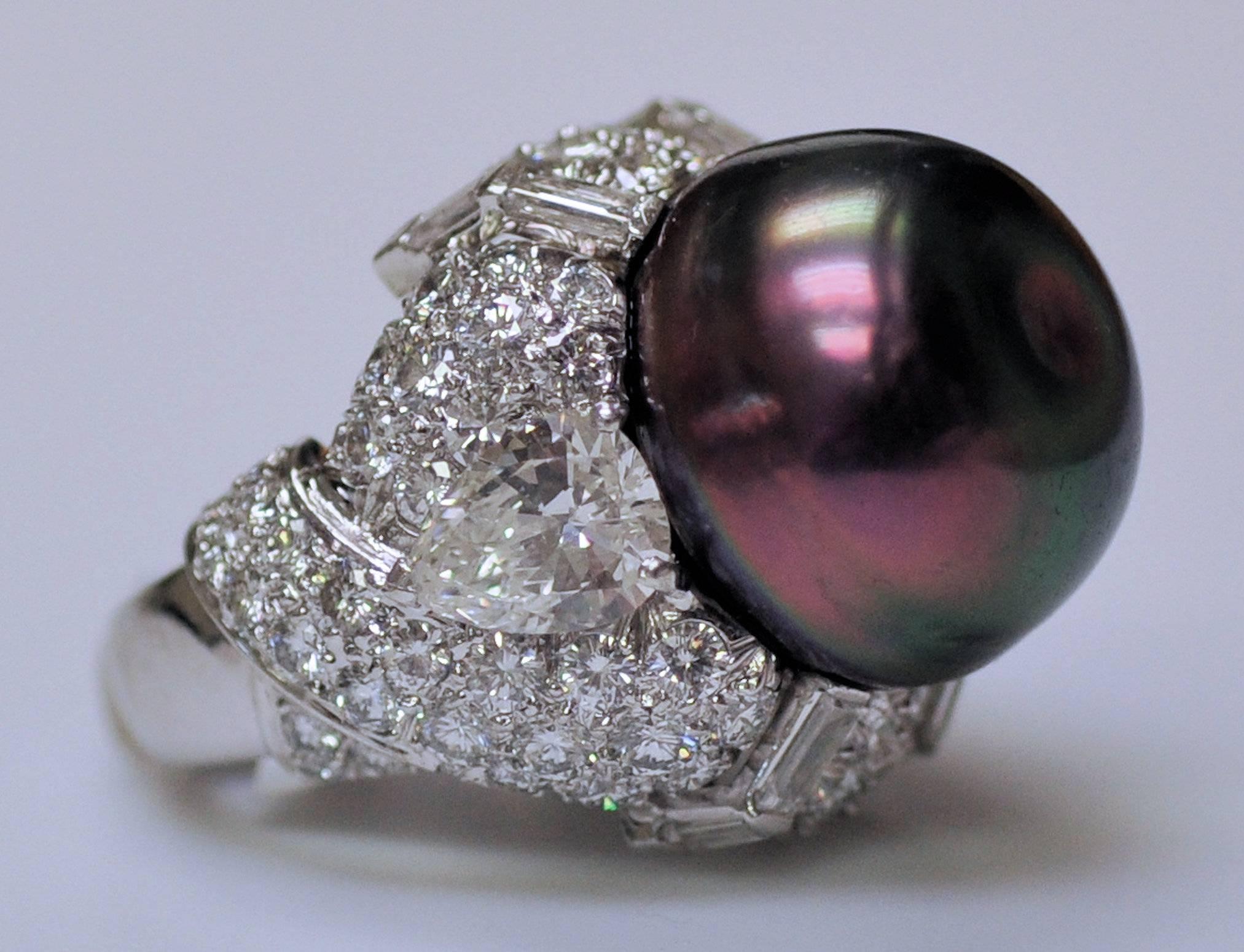 An exquisite example of this American maker's fine craftsmanship.  One of a kind platinum swirl ring with matched pear shape diamonds, round and baguette cut diamonds. Two pear shape diamonds over one carat each, 8 baguette cut diamonds and 86 round