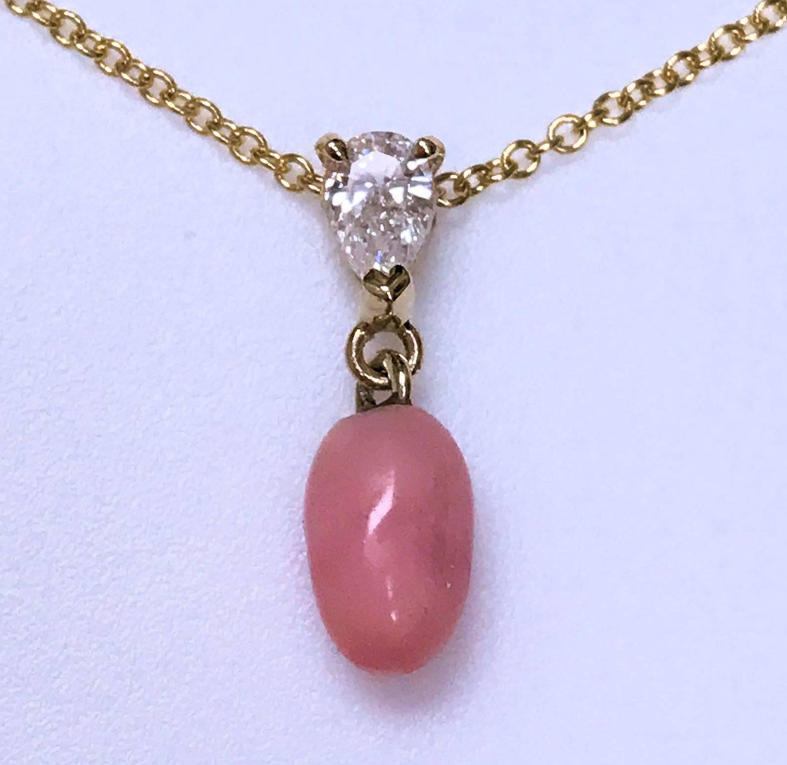 Natural light pink conch pearl with the all-important visible flame.  Nice oval shape. It measure 6.9 mm long and 4 mm. wide. This pendant is set with a pear shape diamond weighing 0.14 carat of grade SI-1, H. 14 karat yellow gold setting and chain.