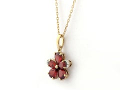 Collar con colgante de flor de oro amarillo de 14K con granate y diamantes
