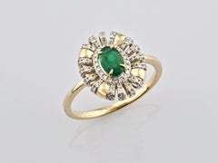 Anillo de oro amarillo de 14 quilates con esmeralda ovalada y diamantes, con diseño «sunburst» y halo