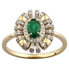Anillo de oro amarillo de 14 quilates con esmeralda ovalada y diamantes, con diseño «sunburst» y halo