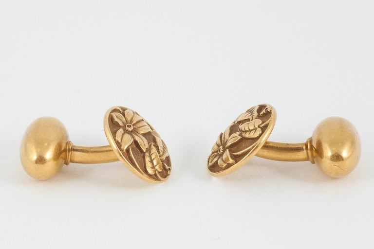 Pair of Art Nouveau period 15k [stamped] gold cufflinks of floral design with a fine patina.Signed with the Scabbard of Riker Bros,USA circa 1900