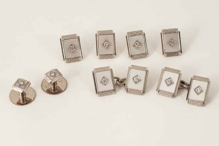 A set of cufflinks,buttons and studs mounted in 18ct white gold,faced in platinum with carved mother of pearl,and centre old cut diamond,English c 1920