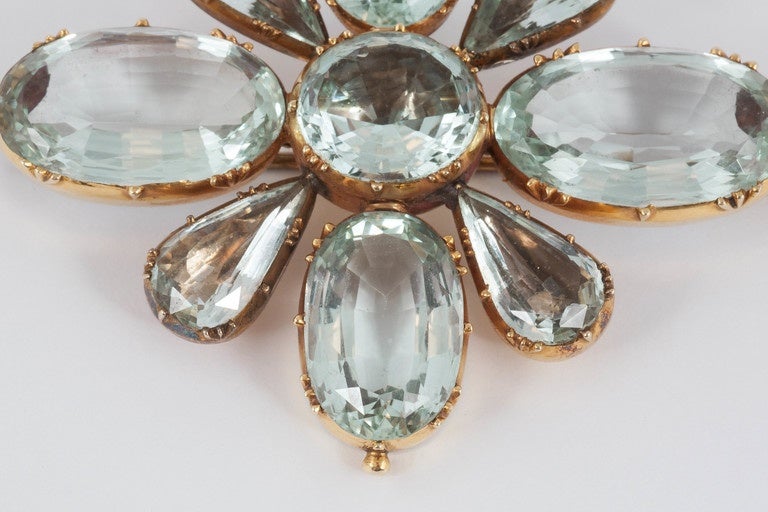 This rare brooch has 4 foiled aquamarines and 4 open back stones.
