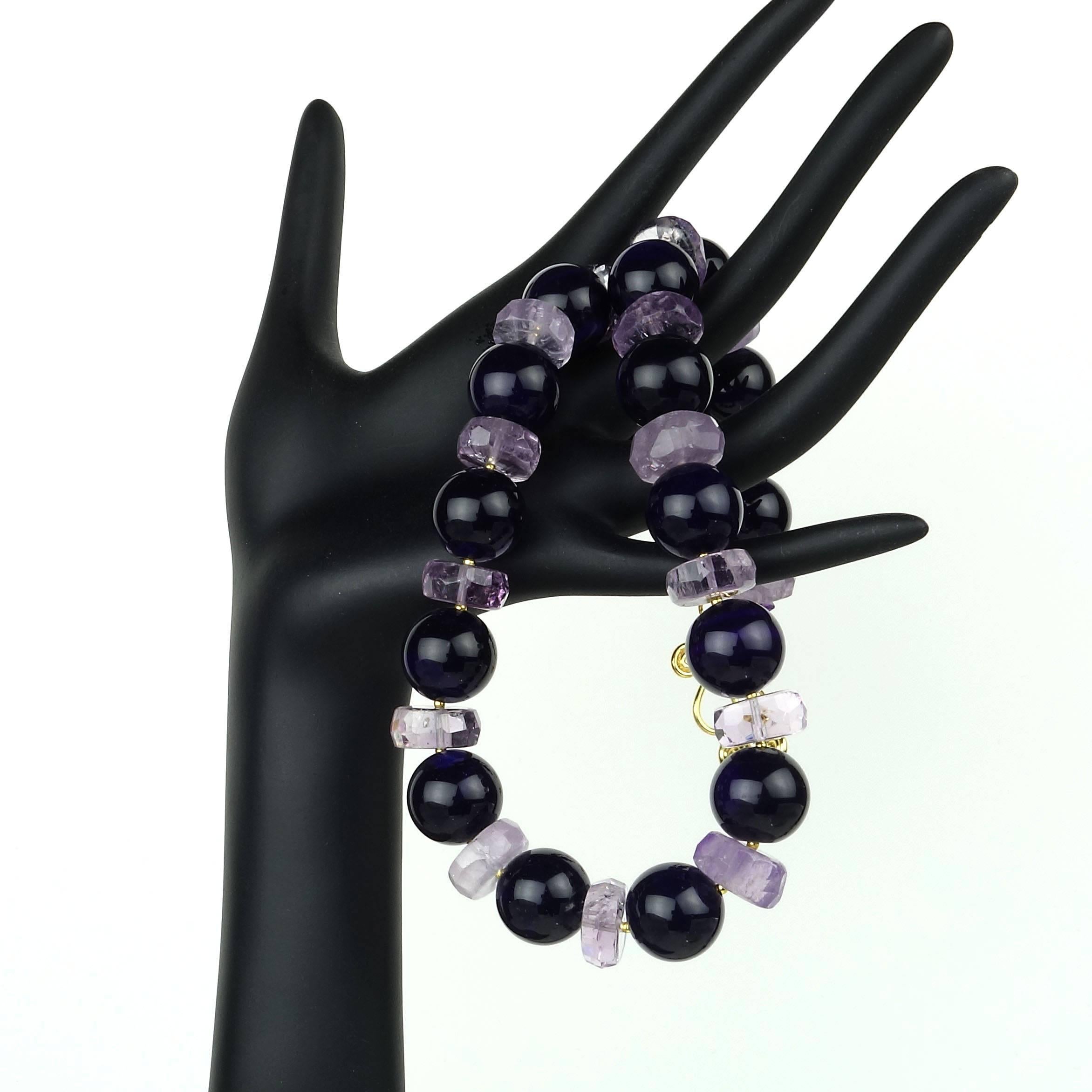 Facinating Rondels of Sparkling Amethyst alternating with 16mm spheres of opaque Amethyst in this statement necklace of 19.5 inches.  Tiny gold tone accents spacers and a scrolly 18kt plated clasp accent the amethysts.  Amethyst is the February