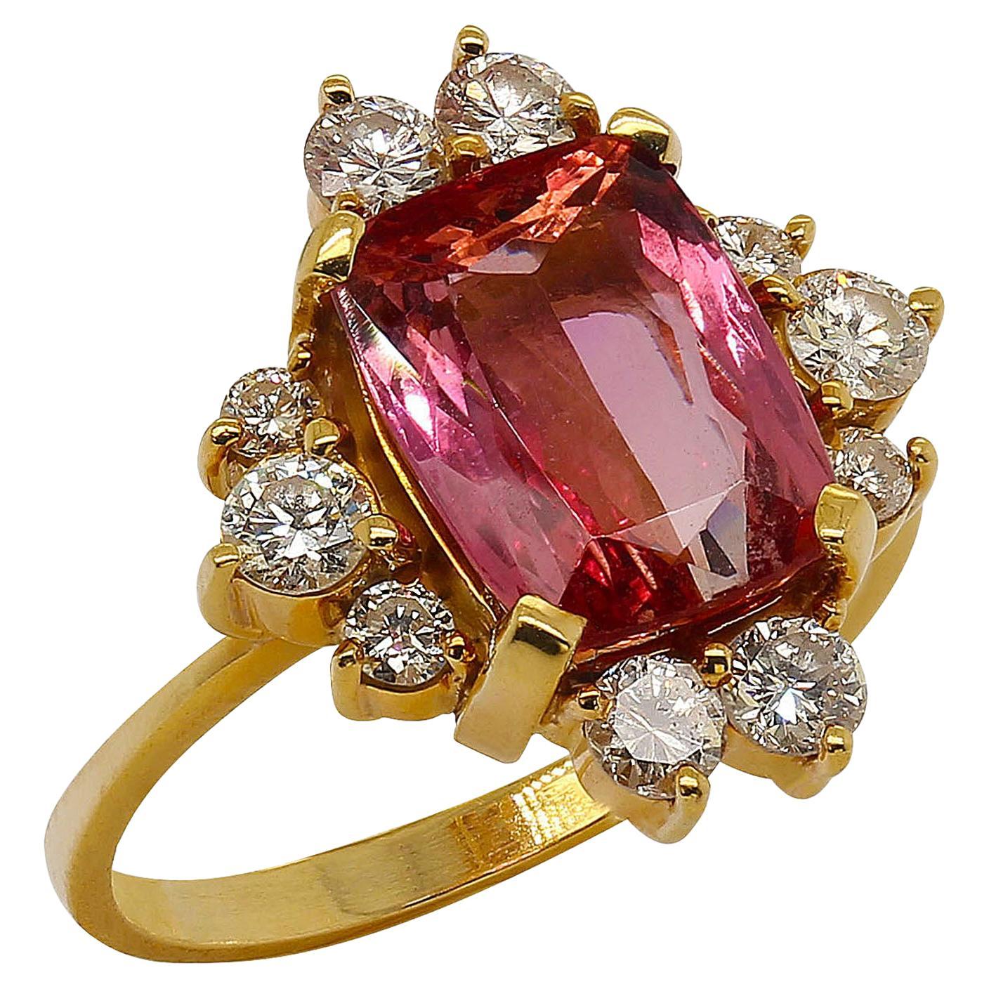 Lovely, sparkling pink Tourmaline enhanced by more sparkle; 10 Diamonds of estimated 0.50 ctw which are G/H color and VS clarity. This gorgeous cushion cut Tourmaline, 10 x 7 MM is nestled in a hand made 18K rich yellow gold setting created in