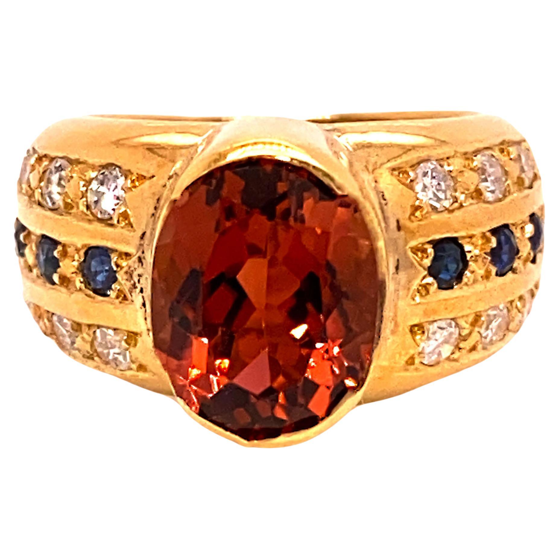 Brilliant Golden Brown Tourmaline in 18K rich yellow gold ring.  This unique ring features an oval sparkling Tourmaline, 9.7 X 7.4 MM, est 2.6 ct. enhanced with 12 diamonds of an est 0.28 ctw, G/H color, SI 1-2 clarity, and 6 blue sapphires. The