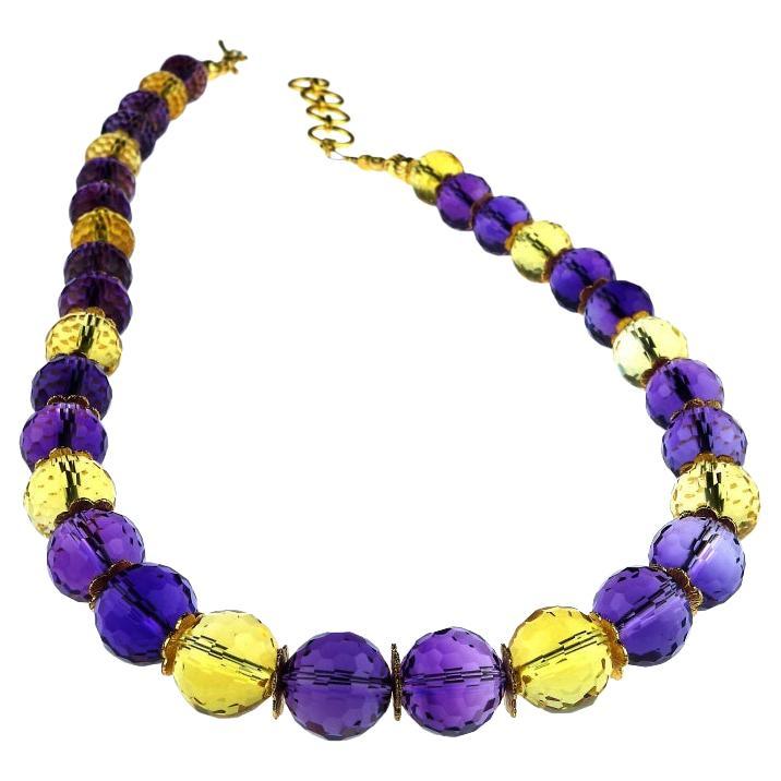 Sparkling Amethyst and Citrine necklace accented with goldtone flutters and finished with an adjustable 18K gold overlay toggle clasp. Length is 18 to 20 inches. The faceted gems are 11.5 MM. This delightful necklace adds sparkle and pop to your