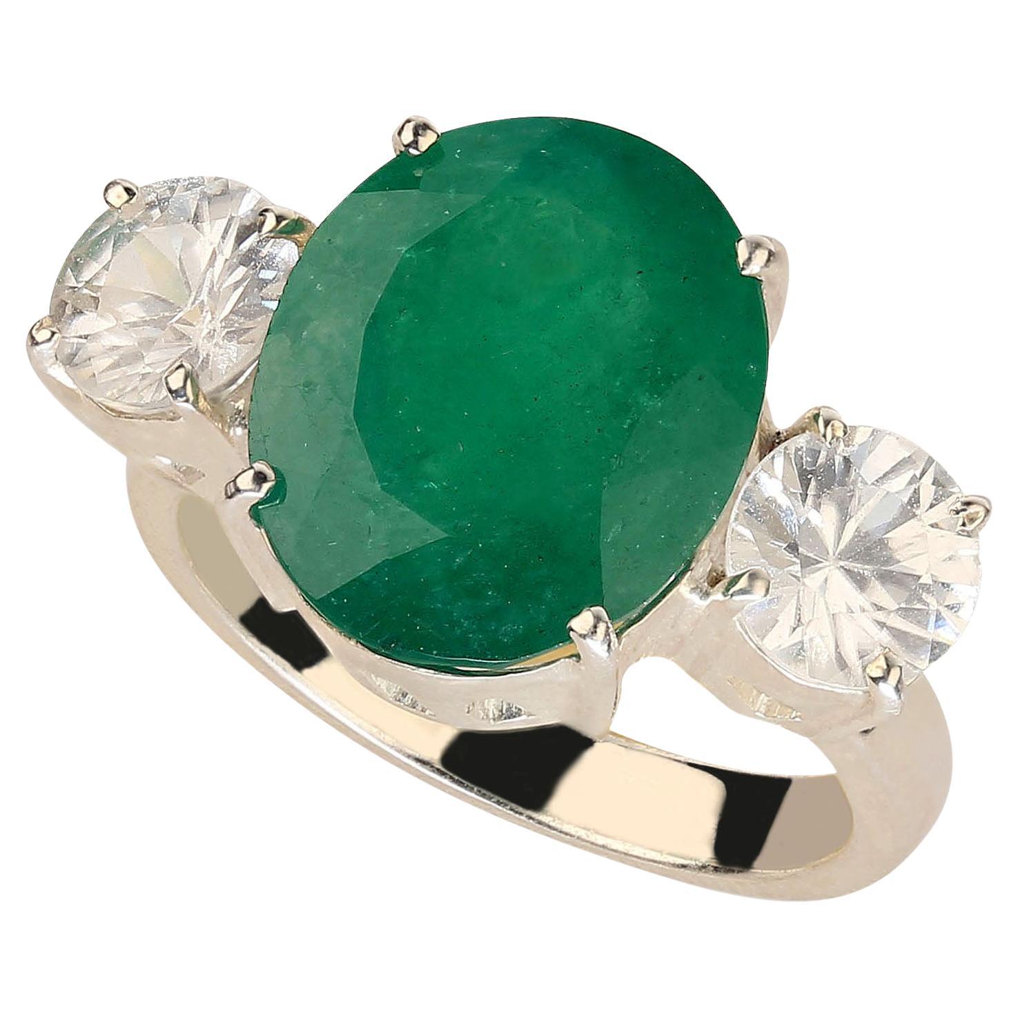 Introducing the Magnificent 6.46-Carat Brazilian Emerald Dinner Ring – a stunning statement piece that is sure to turn heads wherever you go. This exquisite ring features a large oval Brazilian emerald, renowned for its rich green hue, complemented
