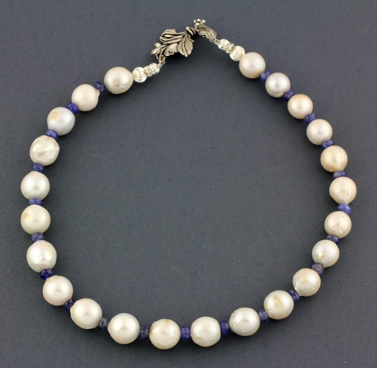 This is a necklace of large, slightly lumpy round magnificent White Tahitian Pearls enhanced with accents of bright blue Tanzanite rondelles.  It's a pleasing length of 20.5 inches and the pearls are approximately 15mm.  The clasp is a lovely
