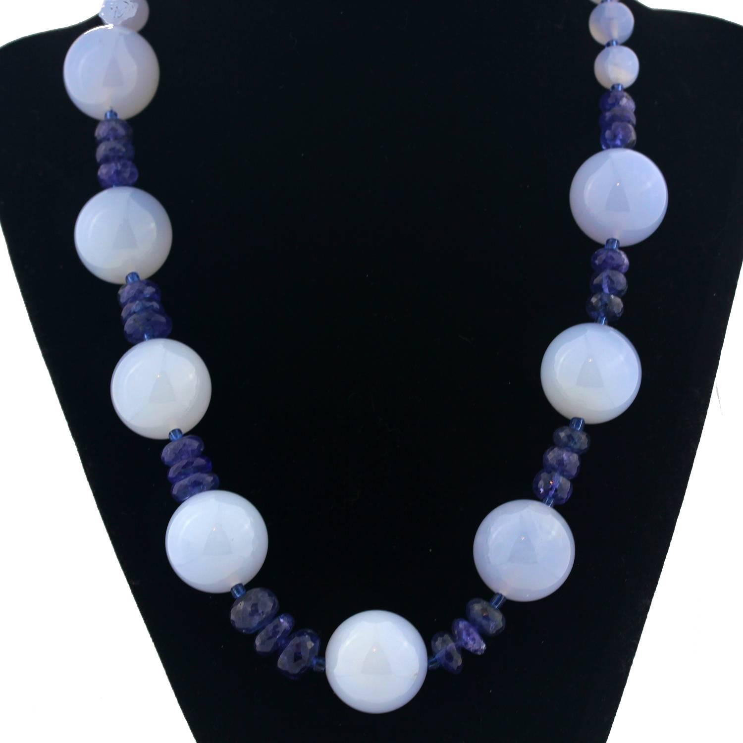 A necklace of Soft beautiful round natural Chalcedony enhanced with bright blue Tanzanites rondelles.  This necklace is 19 inches in length and the large Chalcedony across the front are 20mm.  The clasp is silver tone.
