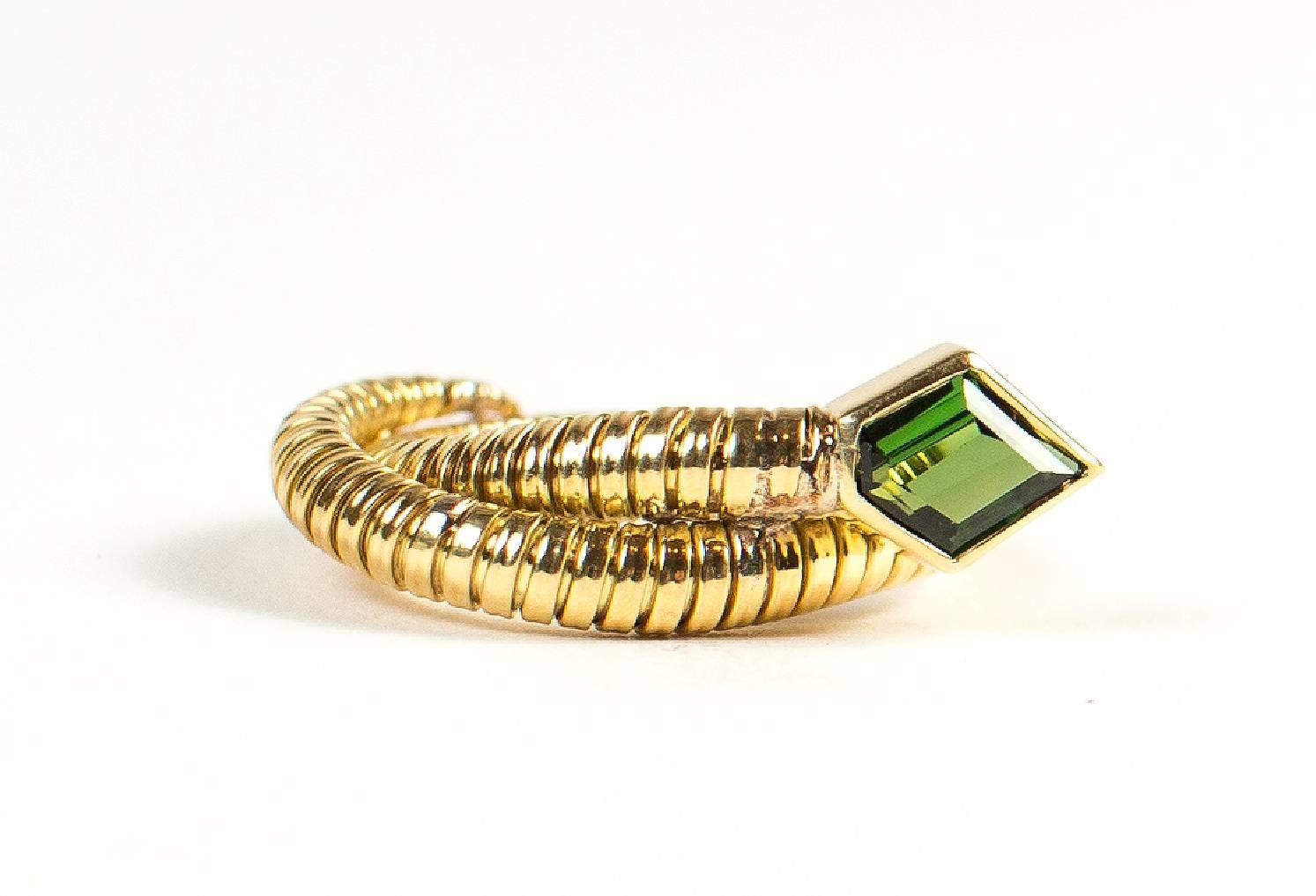 Handmade 18kt yellow gold ring. Flexible shank and freeform almost emerald cut sparkling apple green tourmaline (approximately 5mm x 5mm) bezel set  in what could look like the head of a snake.  This flexible ring is incredibly comfortable to wear