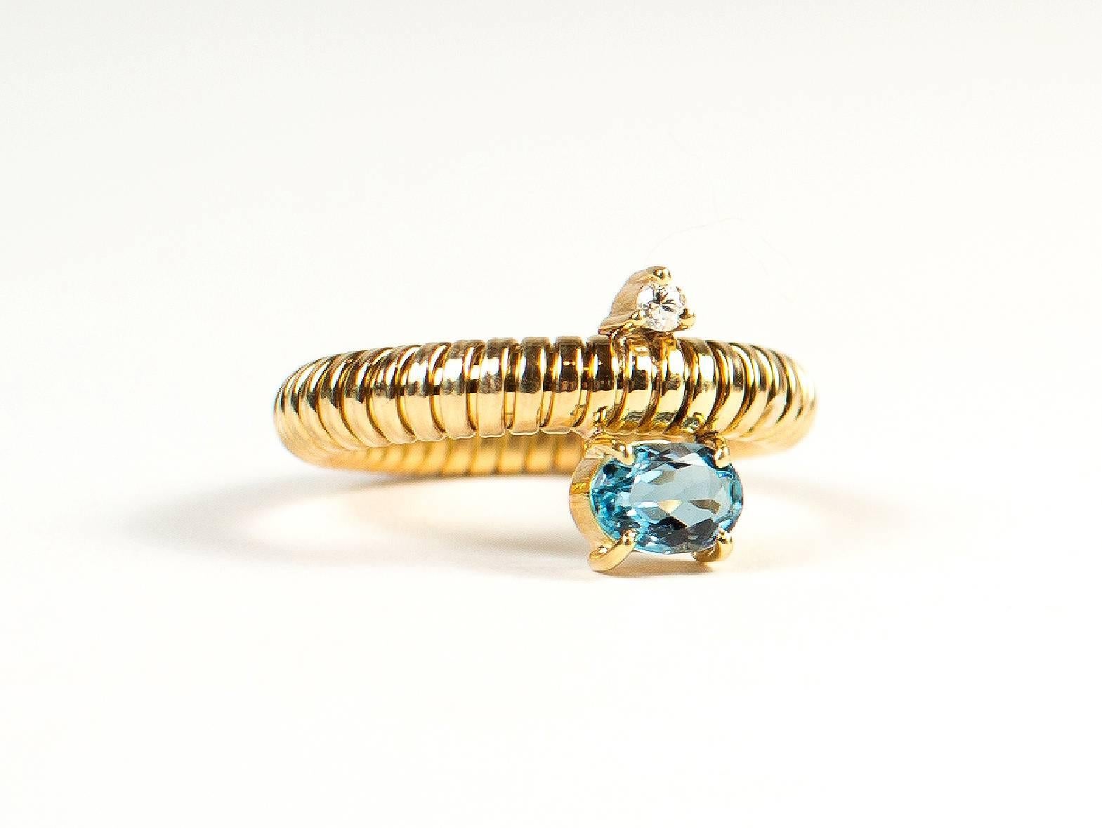 Brazilian handmade flexible 18kt yellow gold ring with sparkling oval aquamarine (approximately 6x4mm) accented with a diamond.   The  flexibility of this ring allows it to easily slip onto you finger, over your knuckle, and fit comfortably.
Size 6.