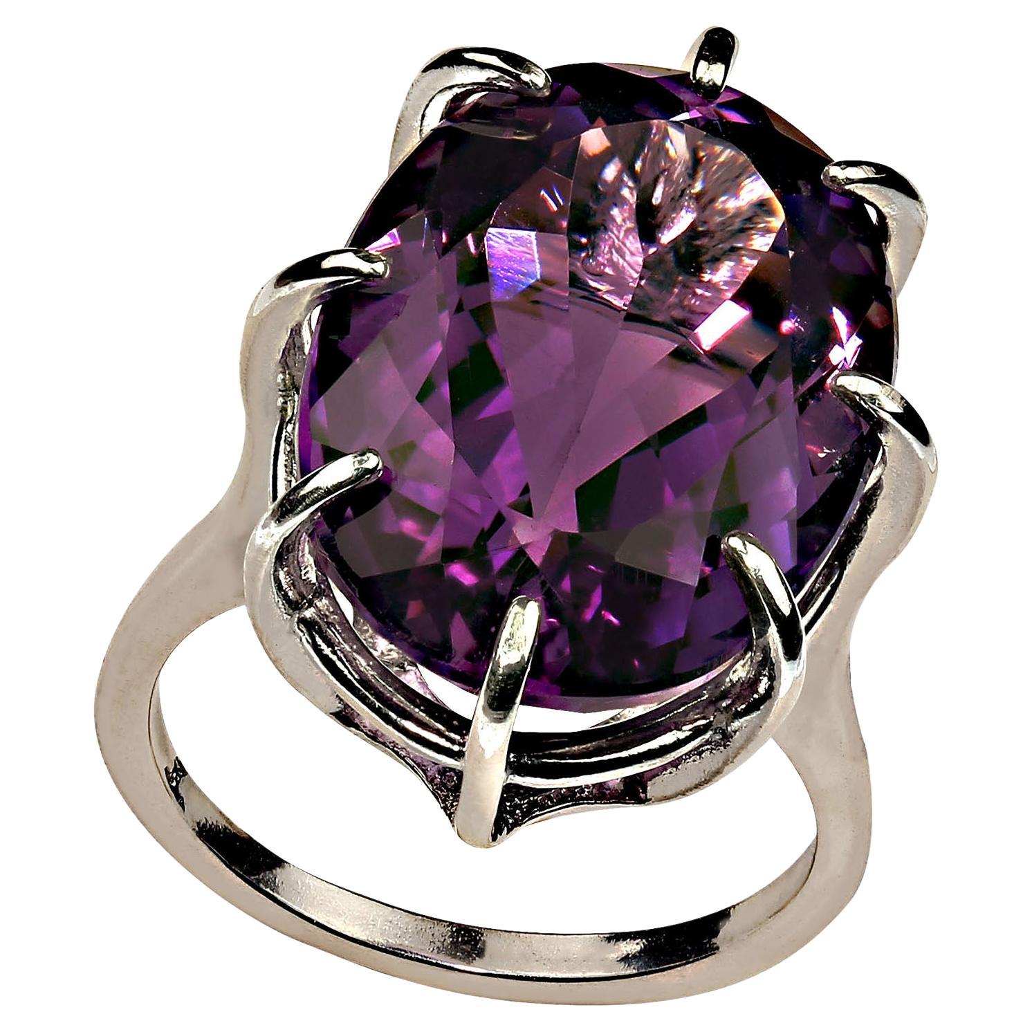 Sparkling oval Amethyst, 14.43 carats, medium color with decidly brilliant pink flash set in a Sterling Silver basket style setting with 8 prongs. Sizable 7. This gorgeous gemstone comes from our favorite supplier up in the mountains outside of Rio