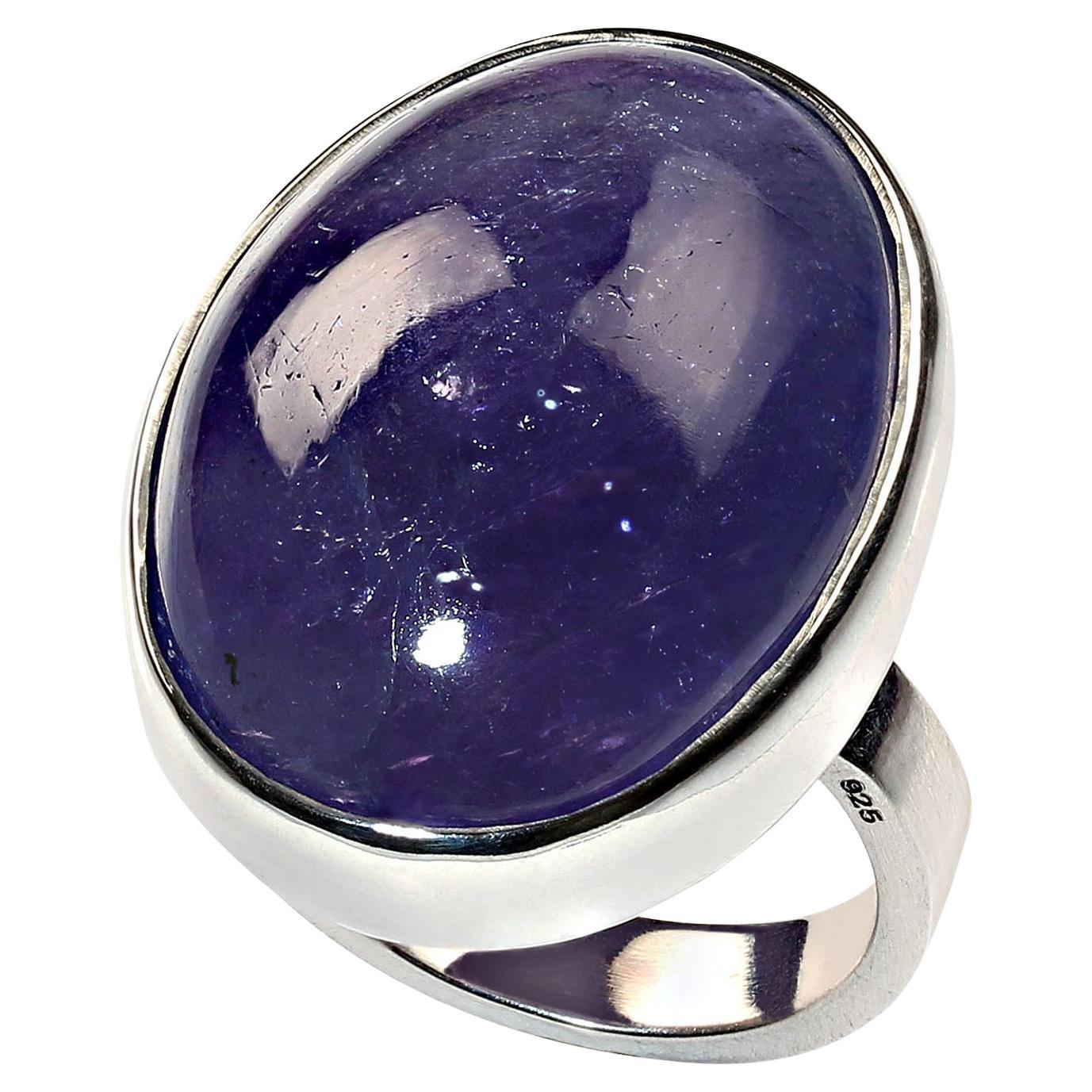 Terrific Tanzanite in a handmade Sterling Silver bezel setting.  This gorgeous 50 carat oval cabochon Tanzanite is a real beauty. It is elegantly displayed in a glowing Sterling Silver ring that was created by one of our favorite vendors in Belo