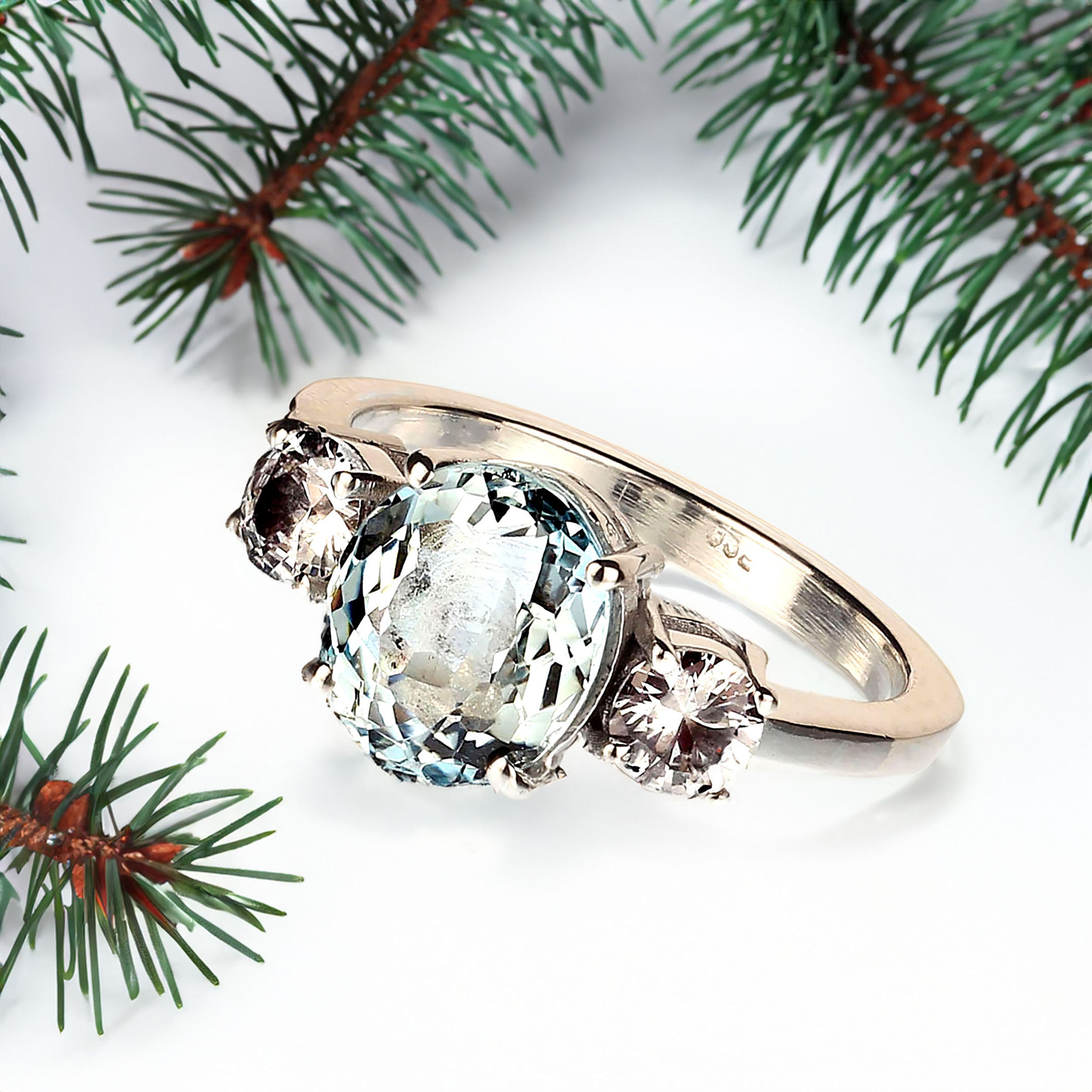 2.8Ct oval light Aquamarine and white Sapphire ring. These lovely gemstones are set in Sterling Silver.  The two round Sapphires total 1.14cts and are perfect accents to the oval Aquamarine which comes straight from one of our favorite vendors in