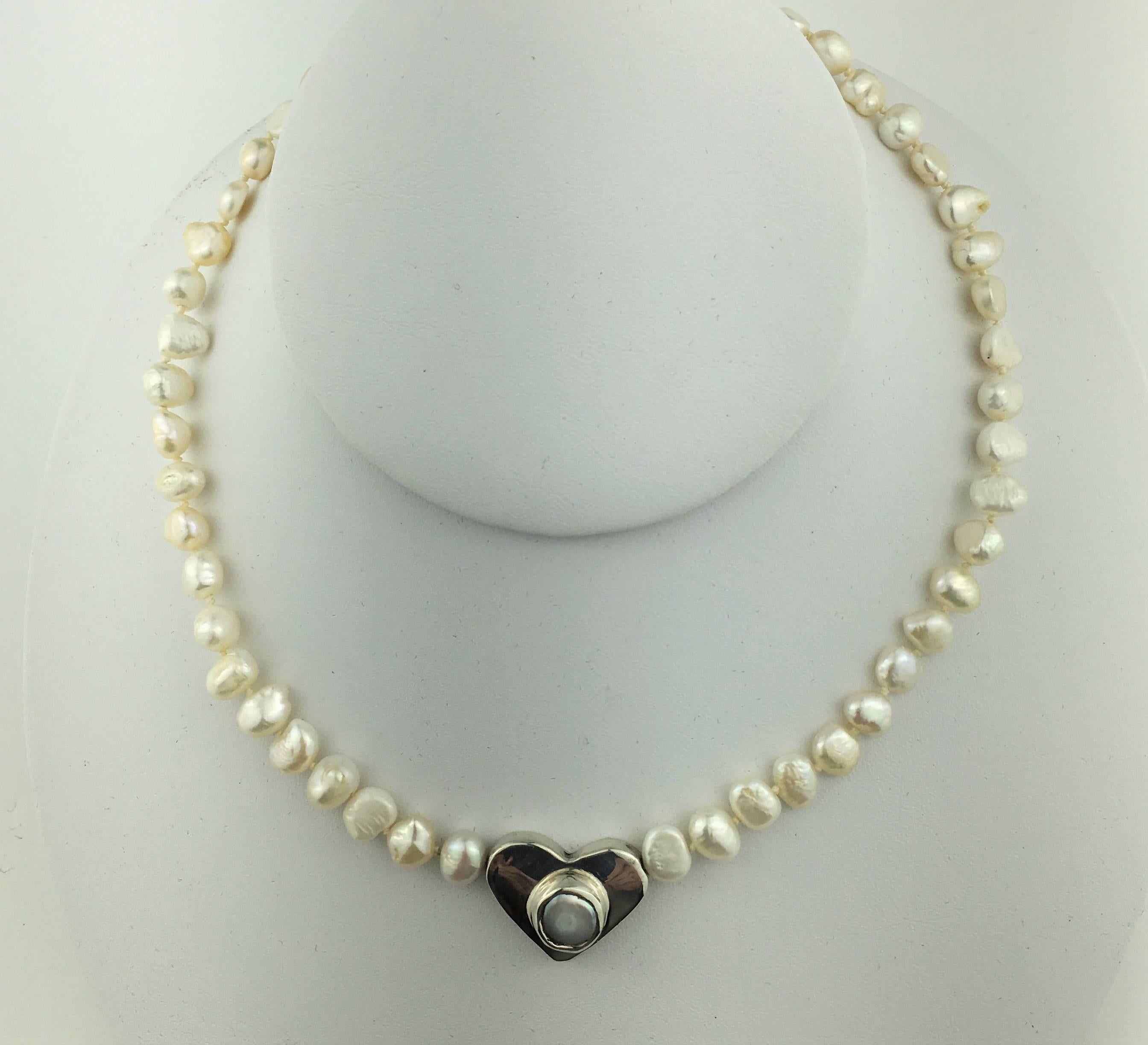 Lovely White freshwater pearl choker necklace with Sterling Silver Heart with a pearl in the center.  This beautiful necklace will go everywhere, put it on and go.  Lobster claw clasp.  15.5 Inch length.

