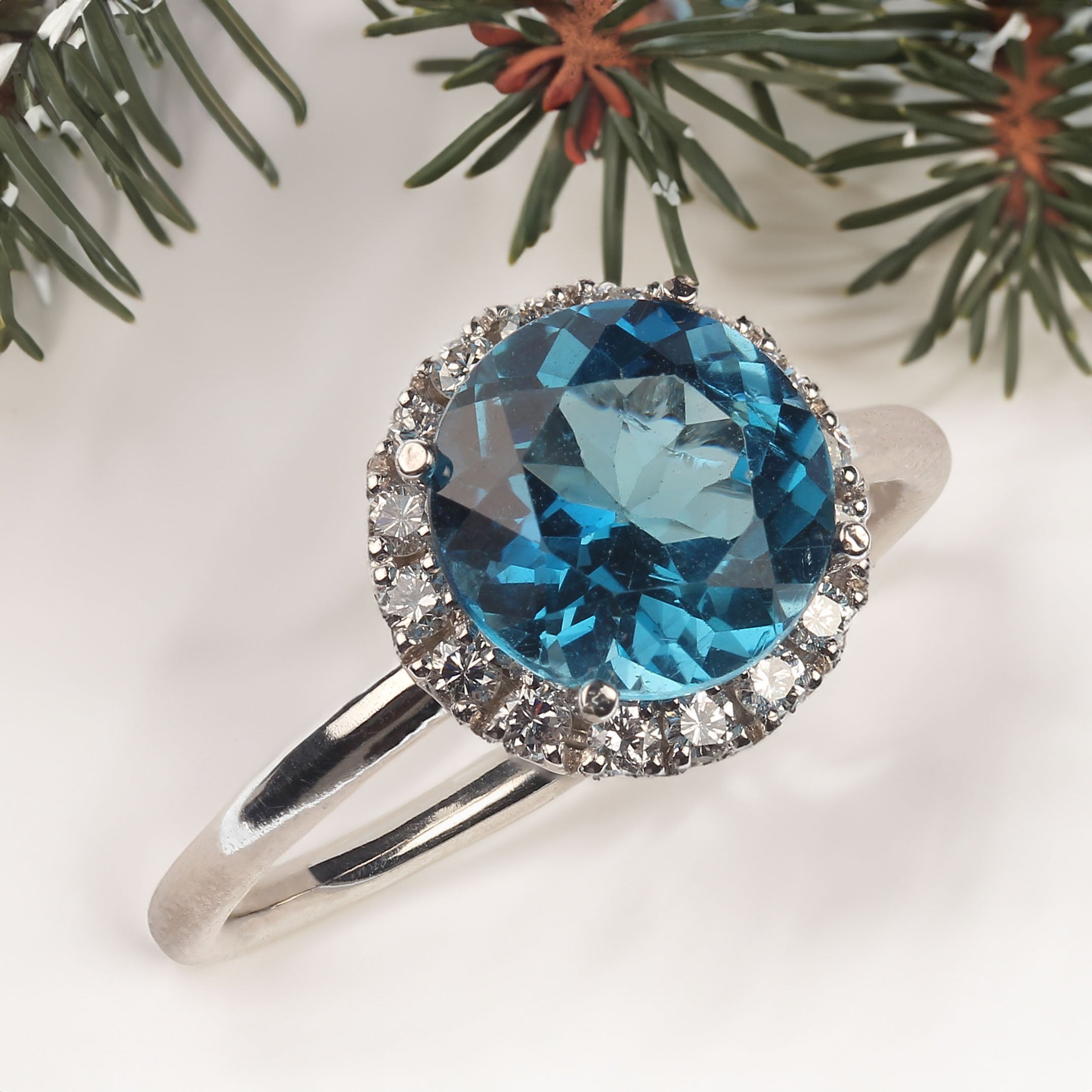 Unique round sparkling Blue Topaz, 2.19ct, and a halo of glittering Diamonds, 0.23ct, all set in 14K white gold ring.  This delightful ring is one of a kind and just what you want for day into evening wear.  No changes by seller.  This is a sizable