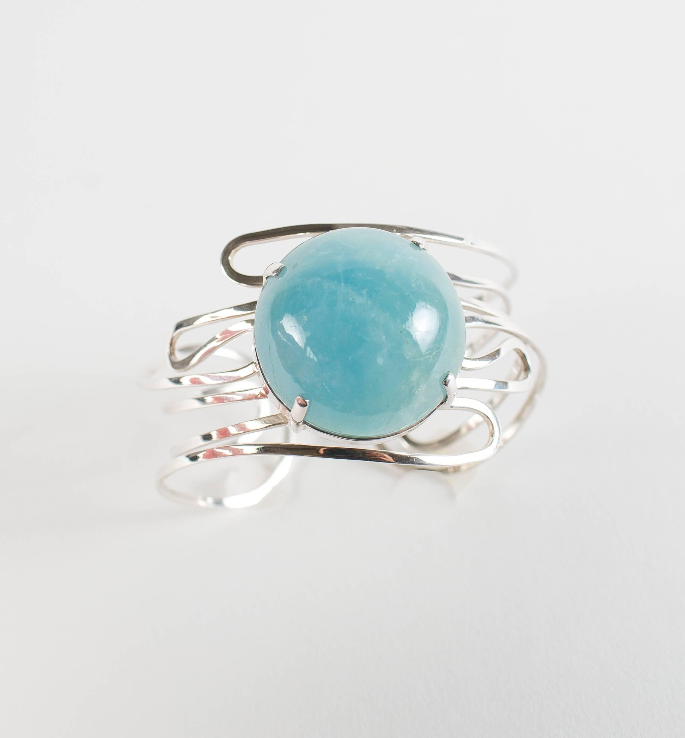 Translucent 102 carat round cabochon aquamarine set in swirls of Sterling Silver handmade Bracelet.  This beautiful bracelet will embrace your wrist and enhance your every ensemble.  The lovely sea blue Aquamarine cabochon is 1 3/16 inches in