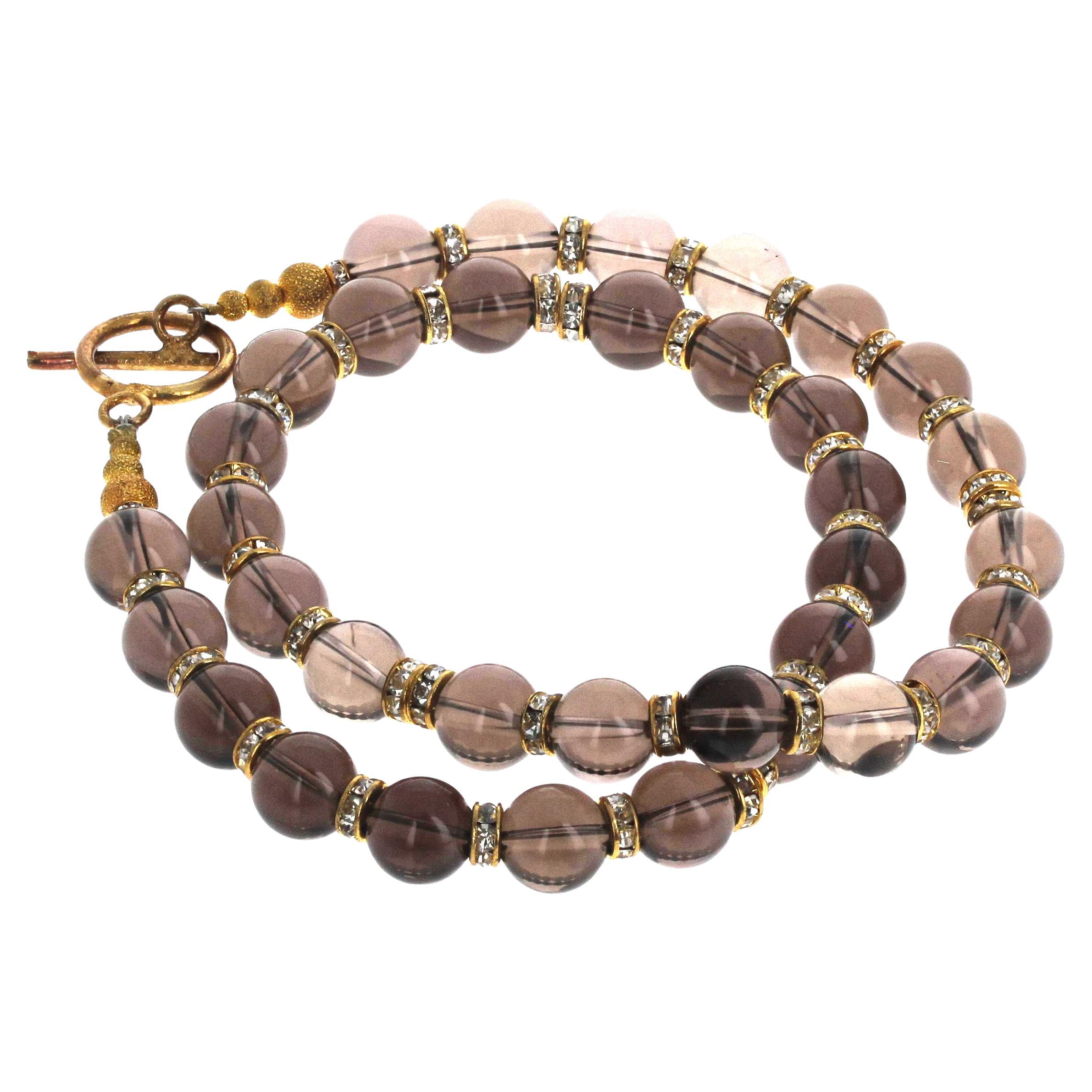 This beautiful outstanding necklace of natural real Smoky Quartz is enhanced with sparkling gold plated spacers.  The Smoky Quartz are highly polished glowing approximately 10mm.  The clasp is an easy to use toggle clasp.  This is lovely to wear on