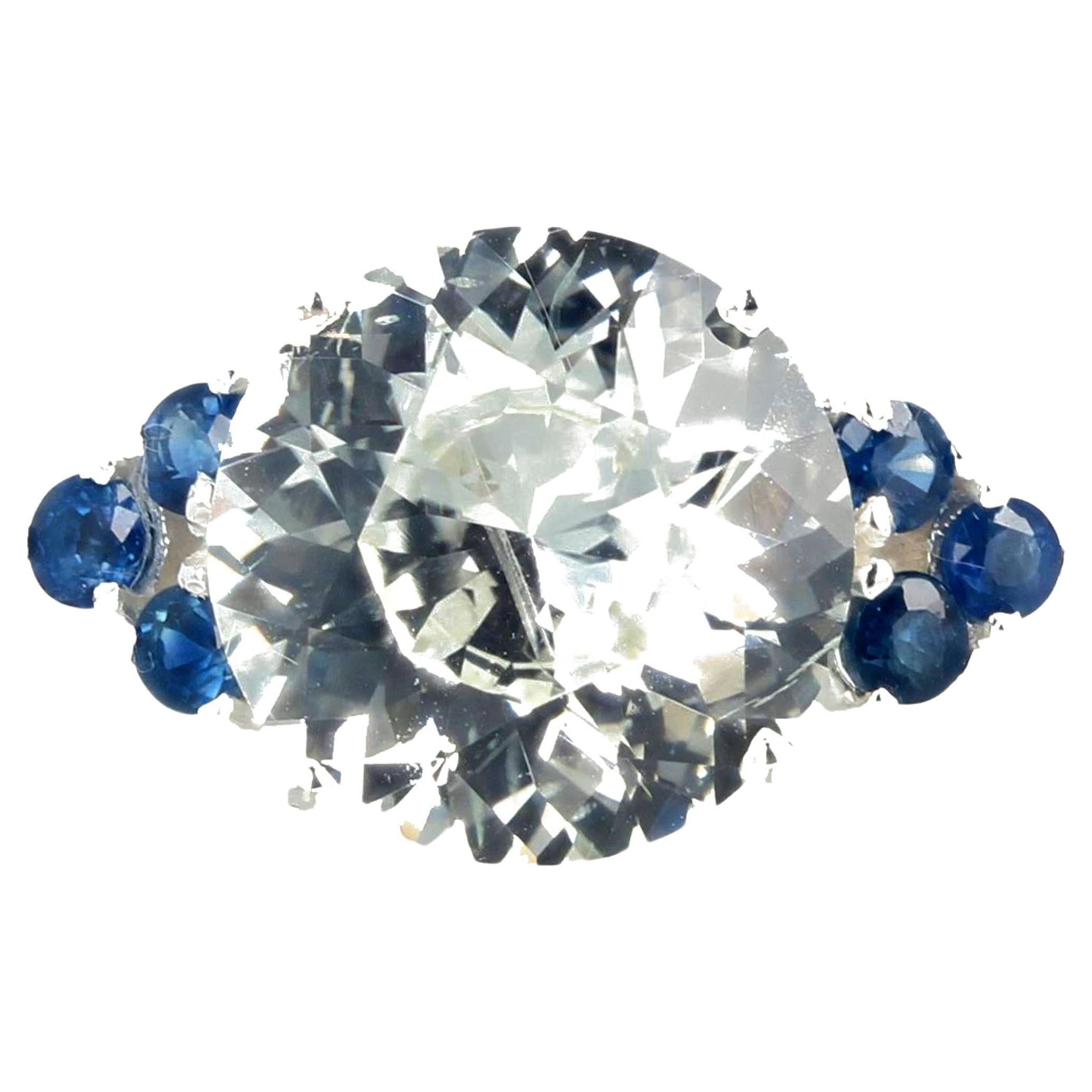 This stunning glittering 6.52 carat natural white Zircon has more fire than a diamond !  This is a 100 percent natural gemstone that comes from the earth in Cambodia.  The deep blue Sapphire side gemstones are 0.60 carats and the ring is a sterling
