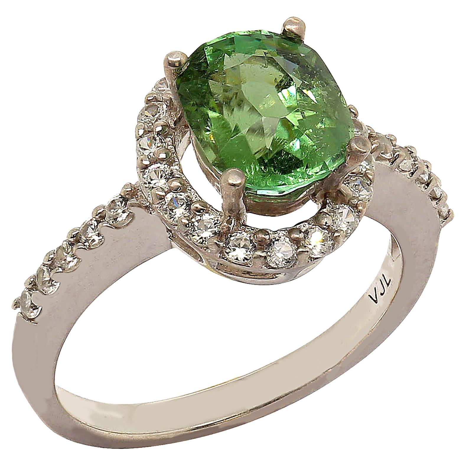 Sterling Silver ring of Brazilian Glowing Green Tourmaline of 2.27 carats halo set with 0.57 carats of white zircon white which continue down the shank. Tourmaline contains multiple colors in one crystal. Its name comes from toramalli, which is the