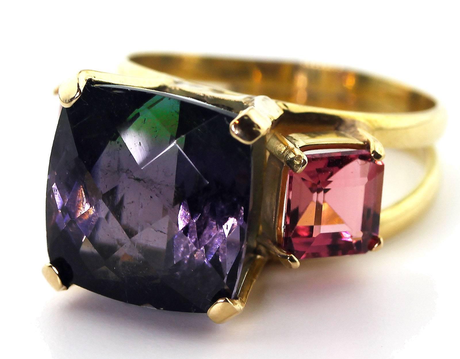 The large sparkling middle 8 Carat checkerboard cut unique Tourmaline is bi-color purple and green so you will find two pictures of it one with purple reflections on top and the other with green reflections on top.  It is enhanced by two pink 1