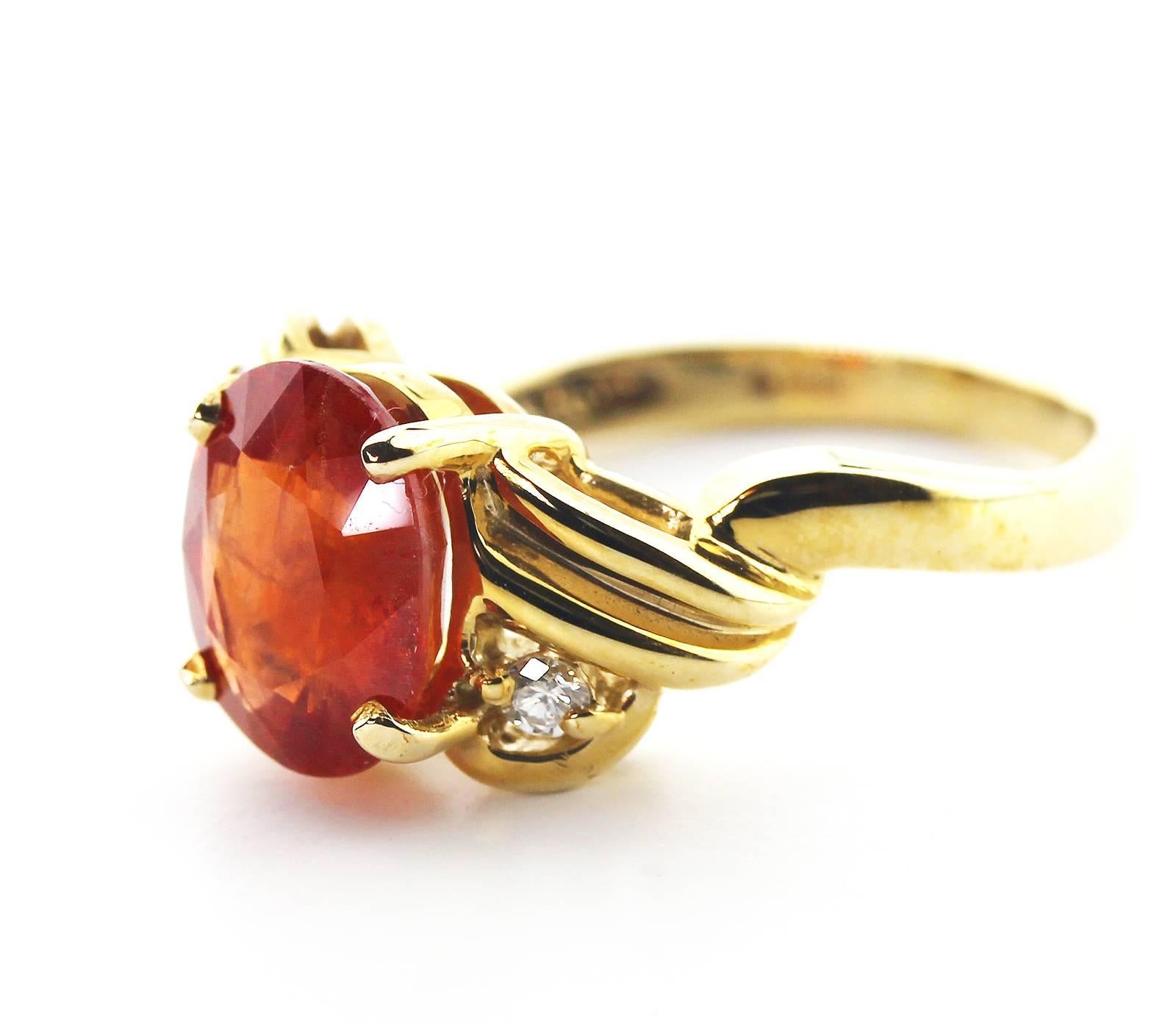 Red/Orangy brilliant 3.24 Carat Spessartite Garnet enhanced with sparkling Diamonds set in 14K yellow gold ring.  The Gemstone is 8.3 mm x 10.2 mm and the ring is a Sizable 7. 