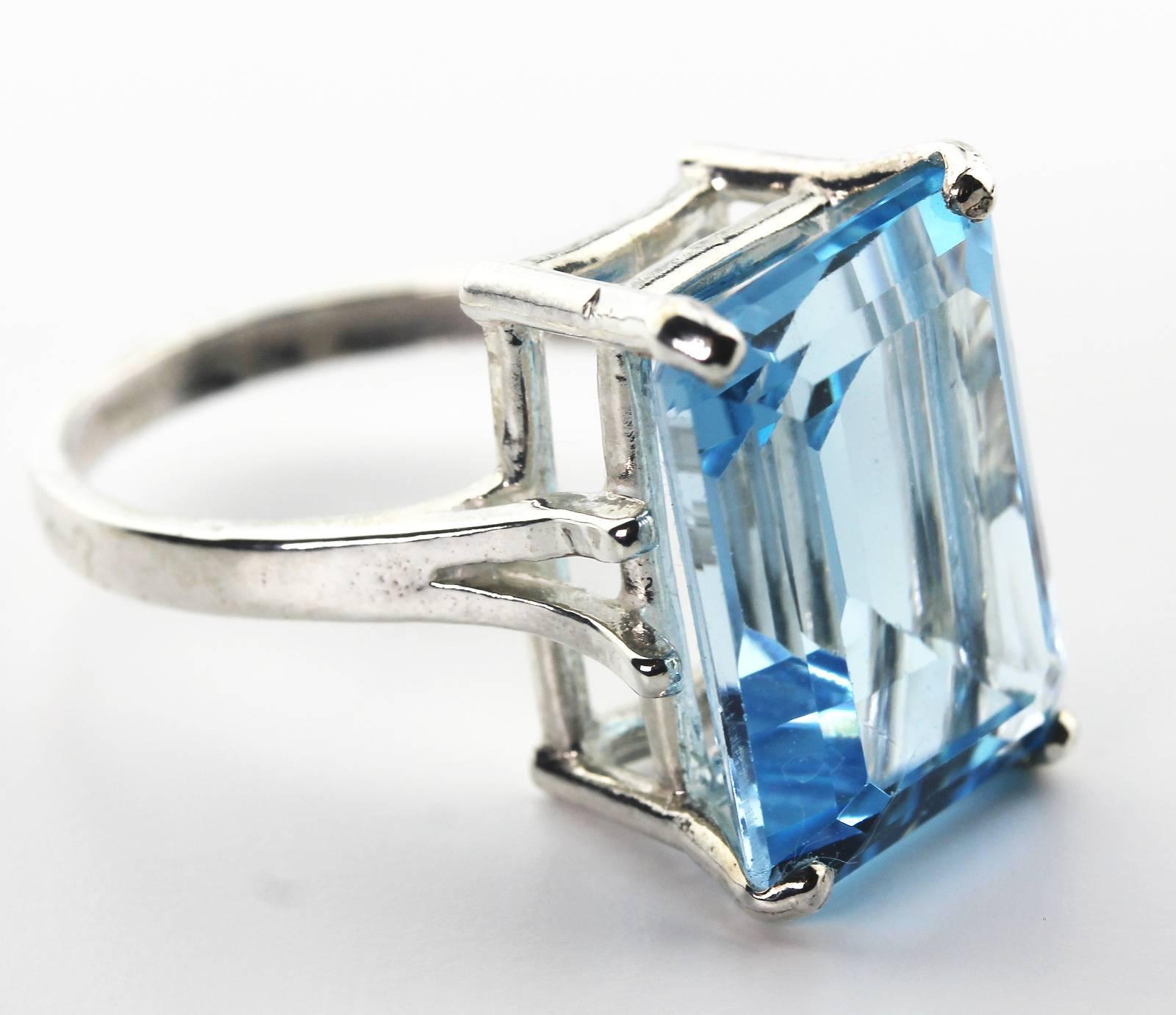 Flawless glittering 18 Carat translucent brilliant emerald cut blue Topaz ring set in Sterling Silver.  The ring is a sizable 7.  The gemstone measures 17.9mm x 13.2 mm or .519 inches x .70 inches.  