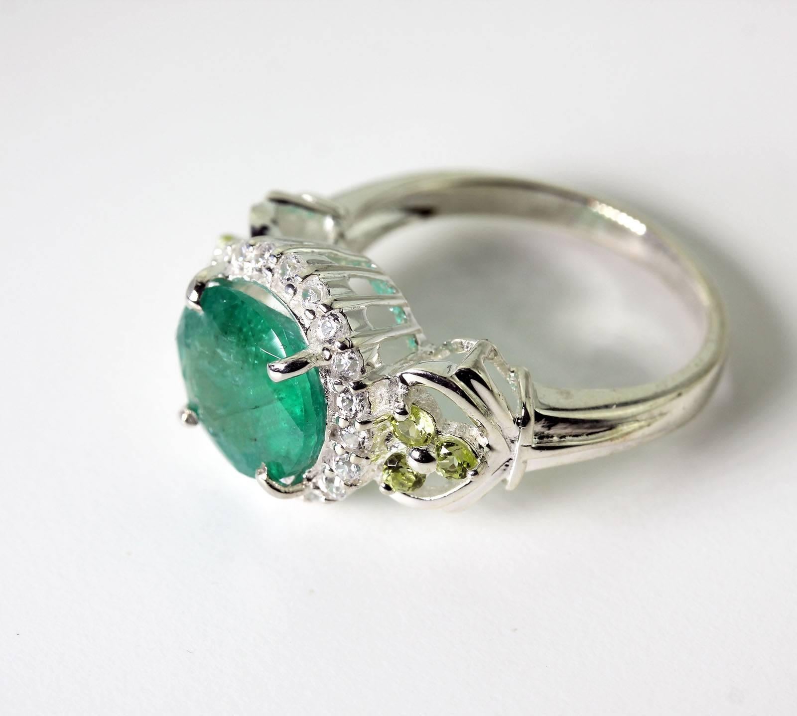 Bright green natural 3 Carat Brazilian Emerald enhanced with tiny little Peridot 
 and itty bitty little natural white Zircons set in Sterling Silver ring.  This Emerald truly sparkles green.
Size:  roval 10.2 mm x 8.7 mm
Ring:  Sterling Silver
Ring