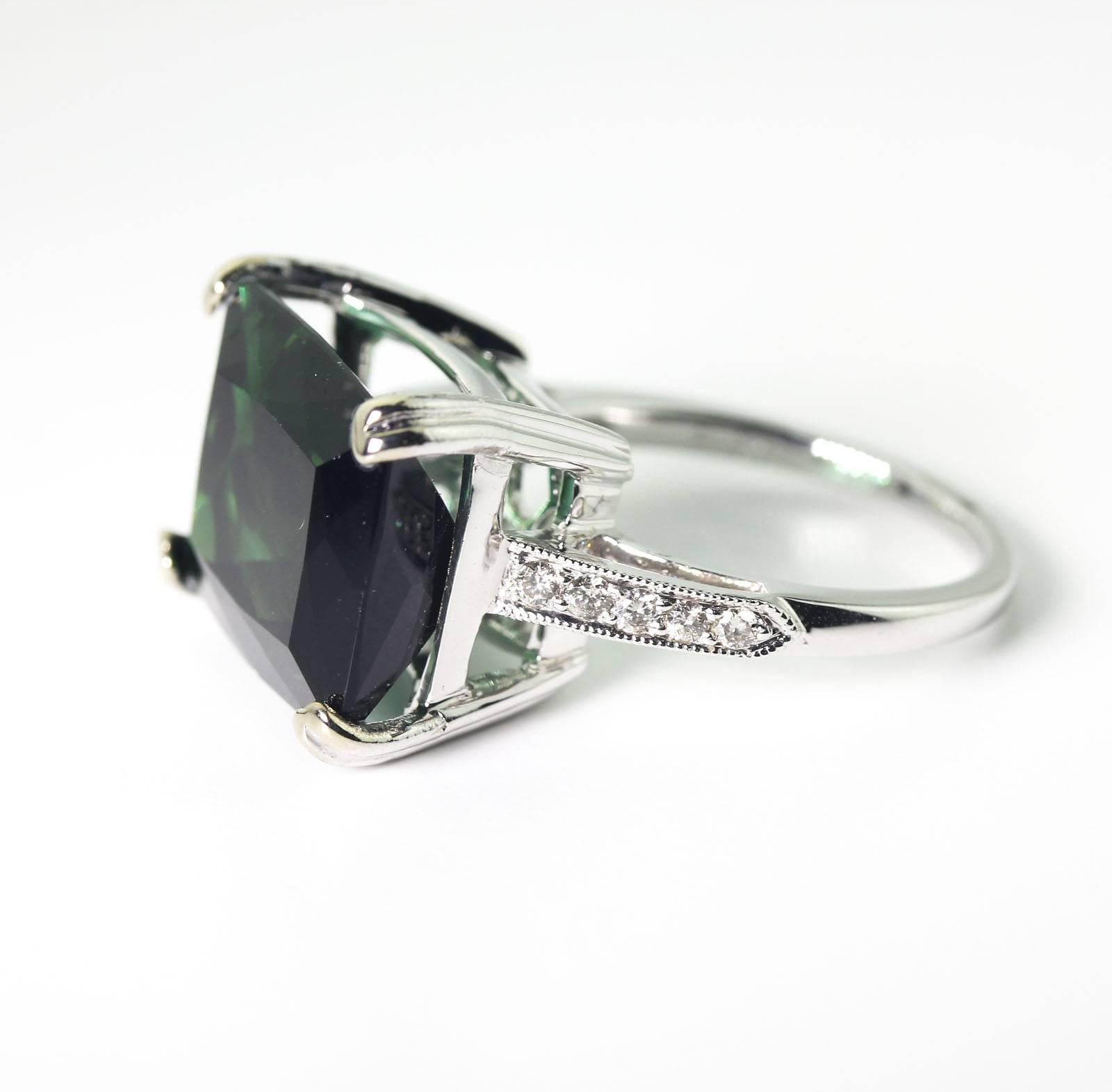 This gorgeous glittering green 9.9 carats of natural Brasilian Tourmaline is enhanced with tiny sparkling white topaz set in 14KT white gold ring.  The handmade unique ring is a size 7 (sizable).  It is so translucent the setting shows through the
